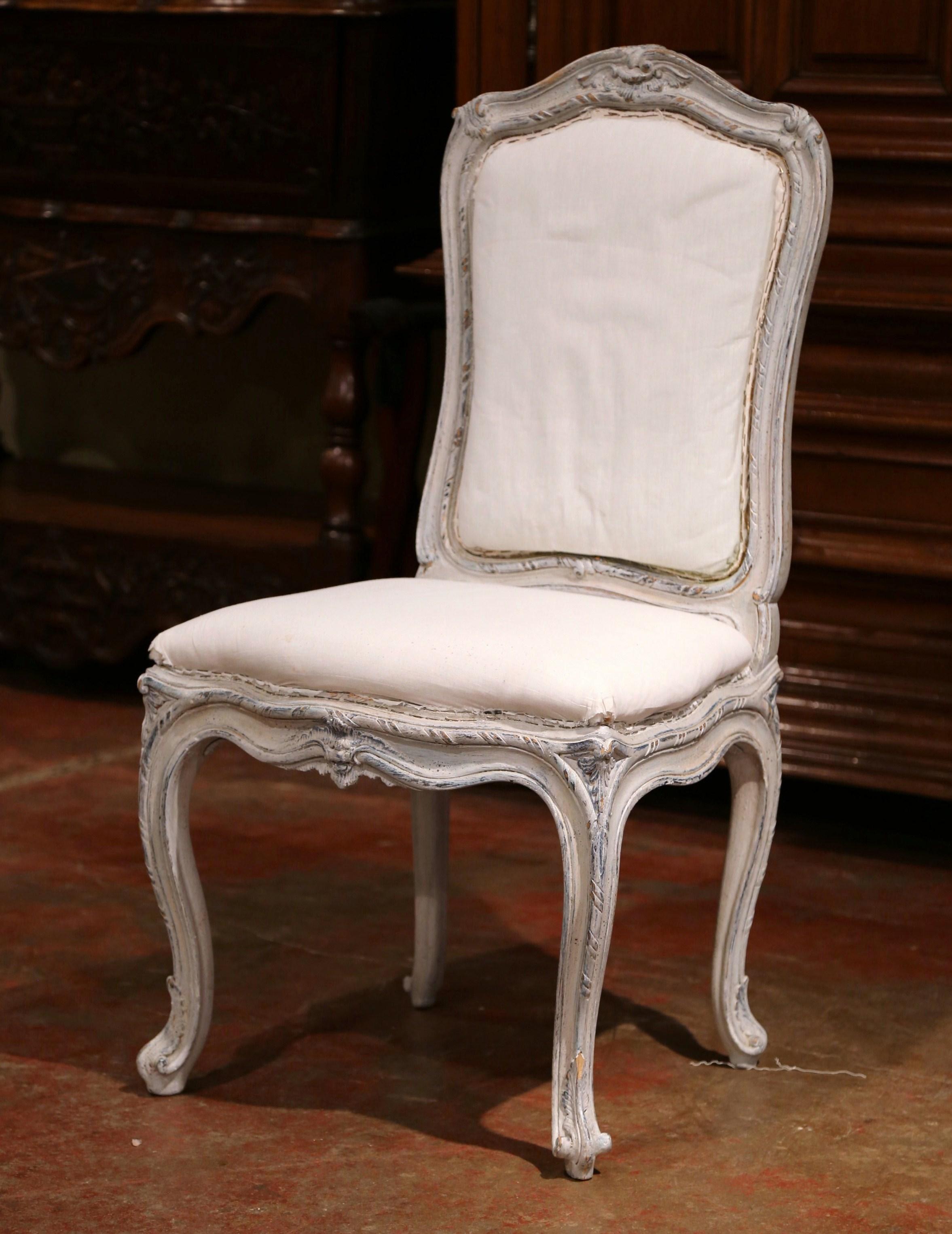 Decorate a dining room with this elegant set of antique, painted, dining room chairs. Crafted in Lyon, France circa 1920, each comfortable side chair stands on cabriole legs with escargot feet over a scalloped apron and a wide and deep seat. The