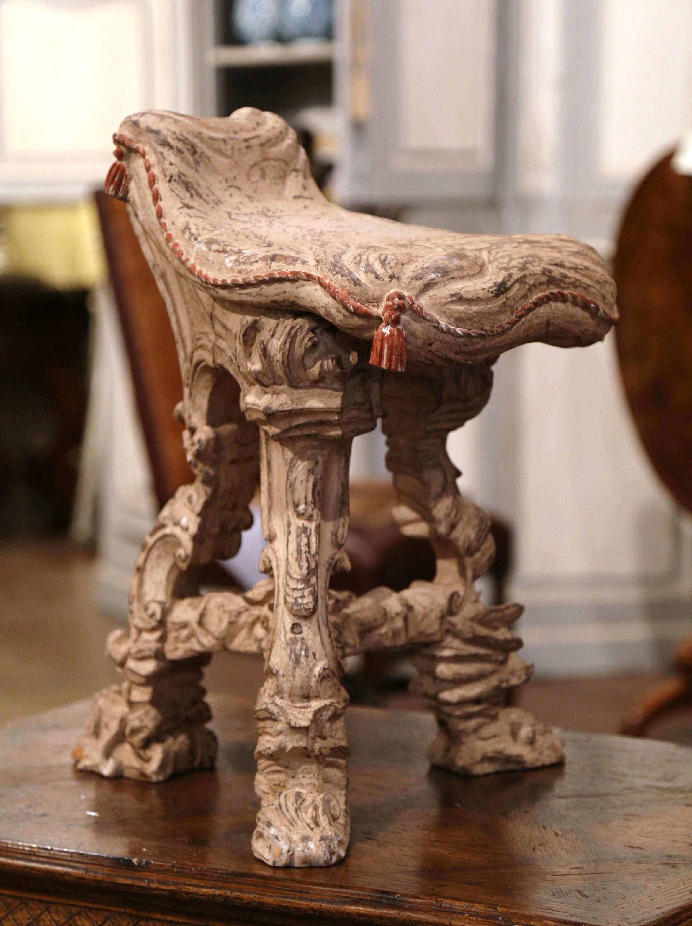 Decorate a master bathroom with this comfortable antique vanity chair; crafted in France circa 1920, the Rococo stool stands on three scrolled legs decorated with carved acanthus leaf and shell motifs. The cushion shape like seat is embellished with