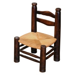 Chaise basse en noyer sculpté du début du 20e siècle avec assise en jonc Chaise basse en noyer sculpté du début du 20e siècle avec assise en jonc