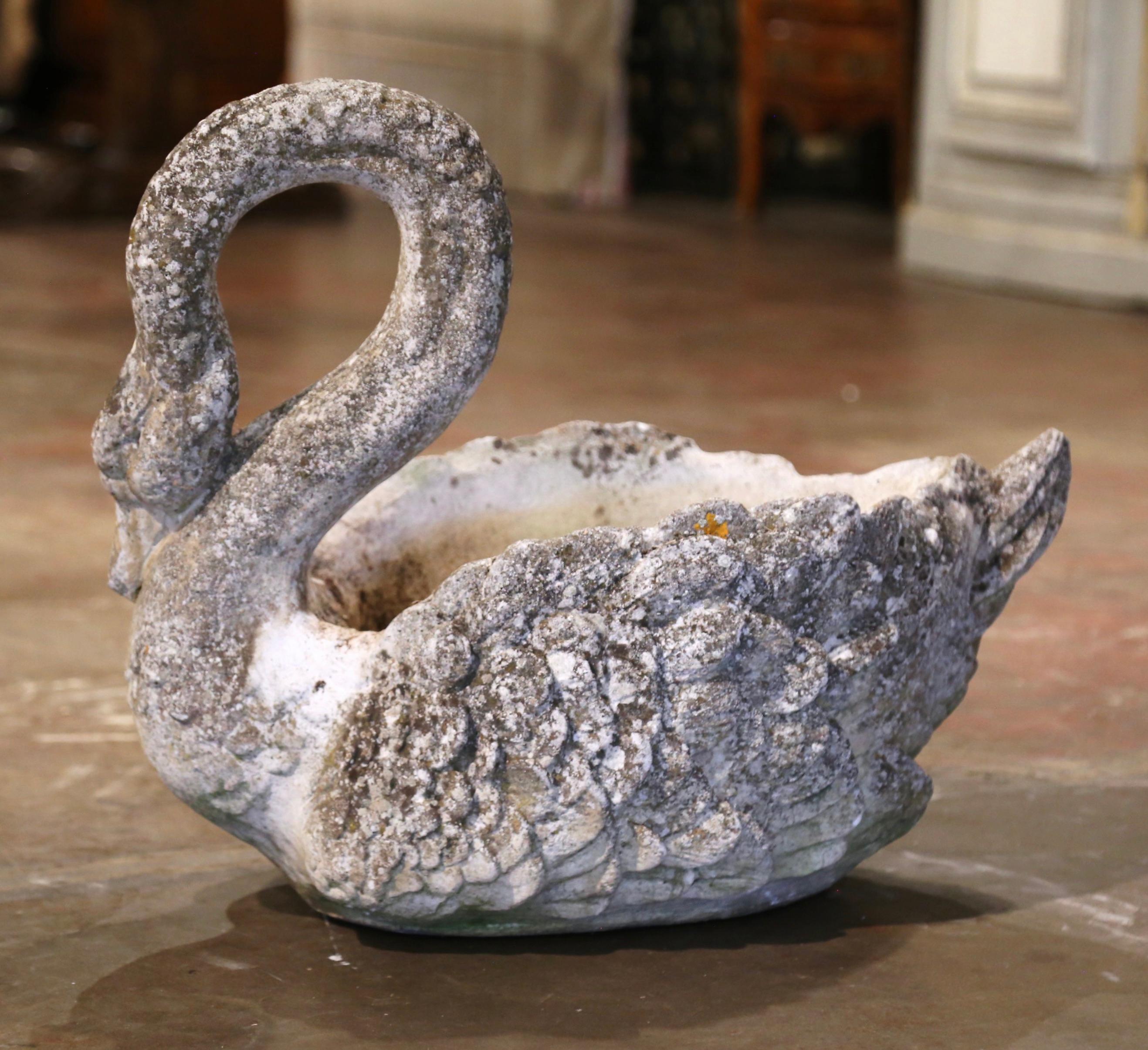 Decorate a patio or backyard with this antique stone Swan planter. Crafted in France circa 1920 and carved of concrete, the sculpture features a regal swan-form dressed with a large flower holder. The bird plant pot contains a hole for drainage. The