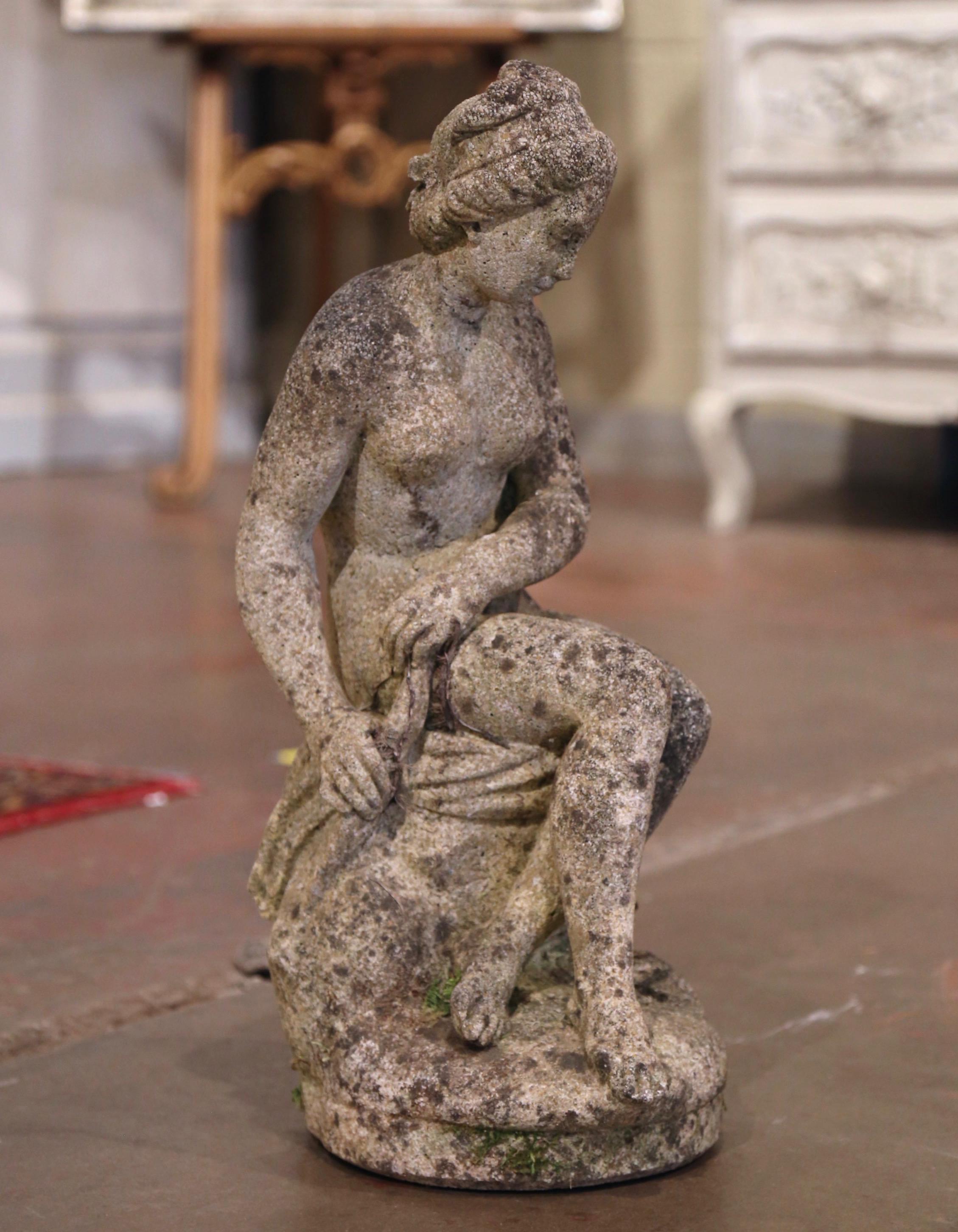 Decorate a garden with this elegant antique outdoor statue; hand carved in France circa 1920, the figure depicts a young goddess sited on a trunk. The statue is in excellent condition with a rich patinated weathered finish. Weight 55