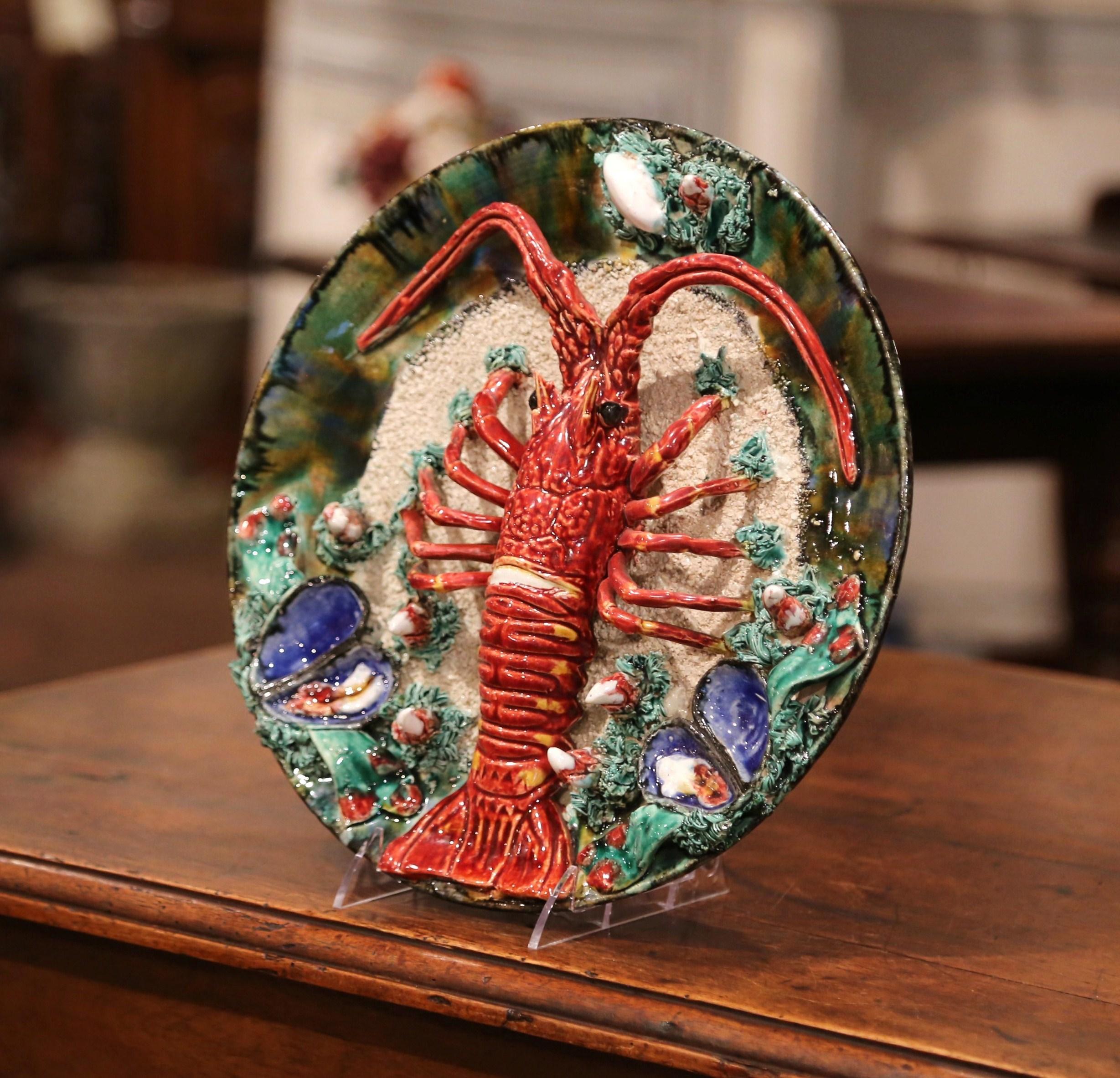 Decorate a wall with this colorful antique hand painted Majolica decorative platter; crafted in Brittany, France, circa 1930, the ceramic plate is sculpted in high relief and decorated with a centre lobster and embellished with clams, mussels,