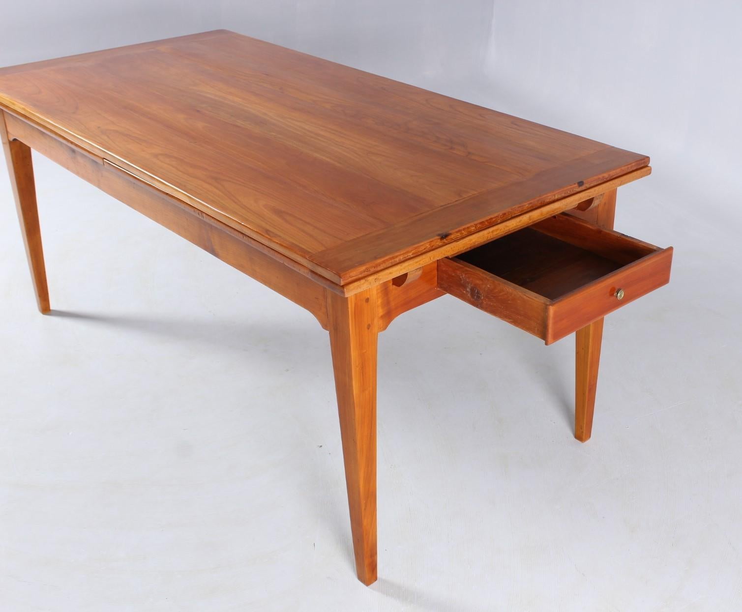 Antique dining table from circa 1910. Solid cherry with old patina. Refurbished ready for living, lovingly restored.

Simple straight legs, no frills, just the pure table.
When pushed together, the table has a length of 180 cm and a width of 89