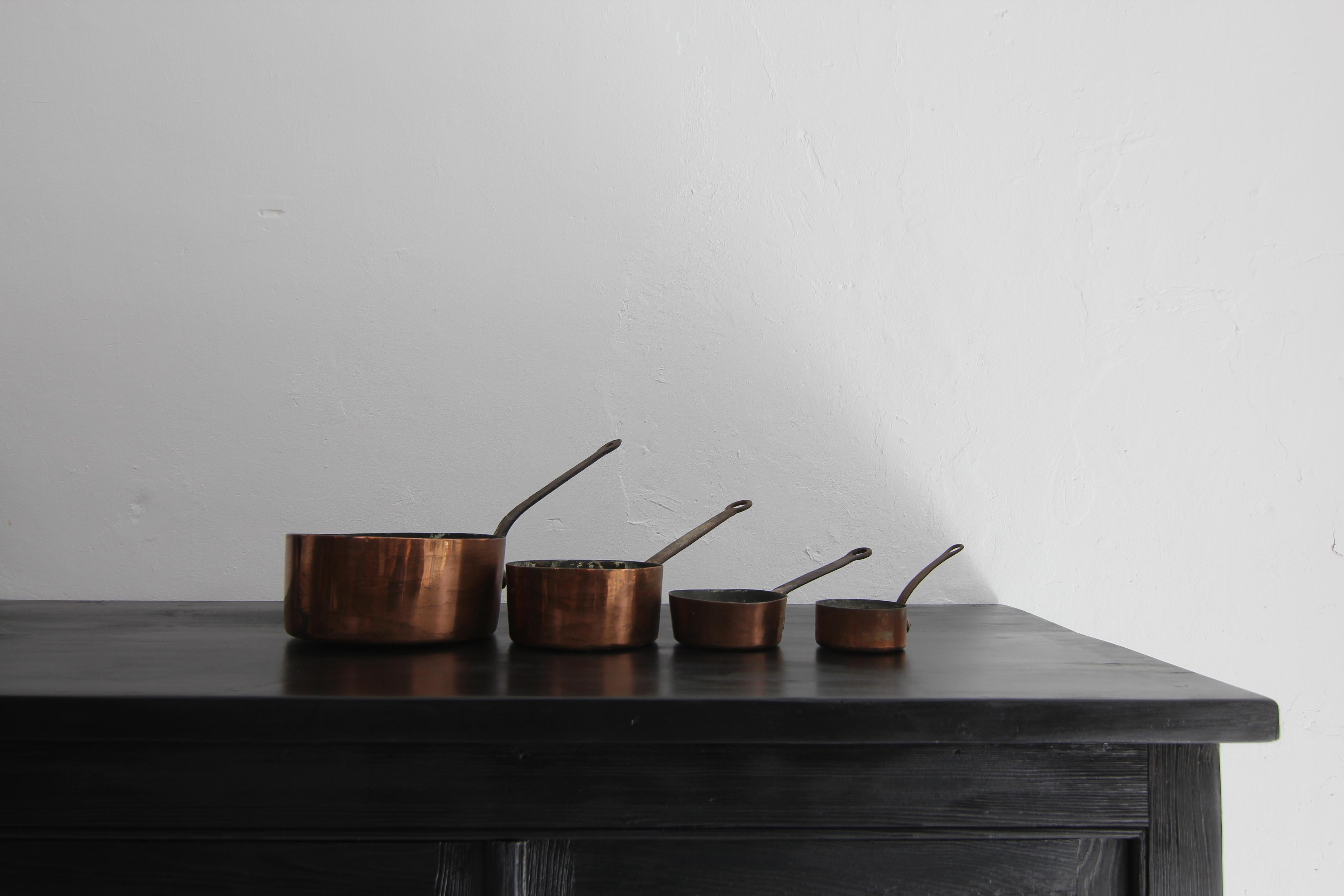 Un ensemble de 4 pots en cuivre français du début du 20e siècle. 

État d'origine non restauré, doublé d'étain, poignée en fer forgé, pot en tôle de cuivre non allié. 

Le cuivre est utilisé et apprécié par l'homme depuis environ 9000 ans. À