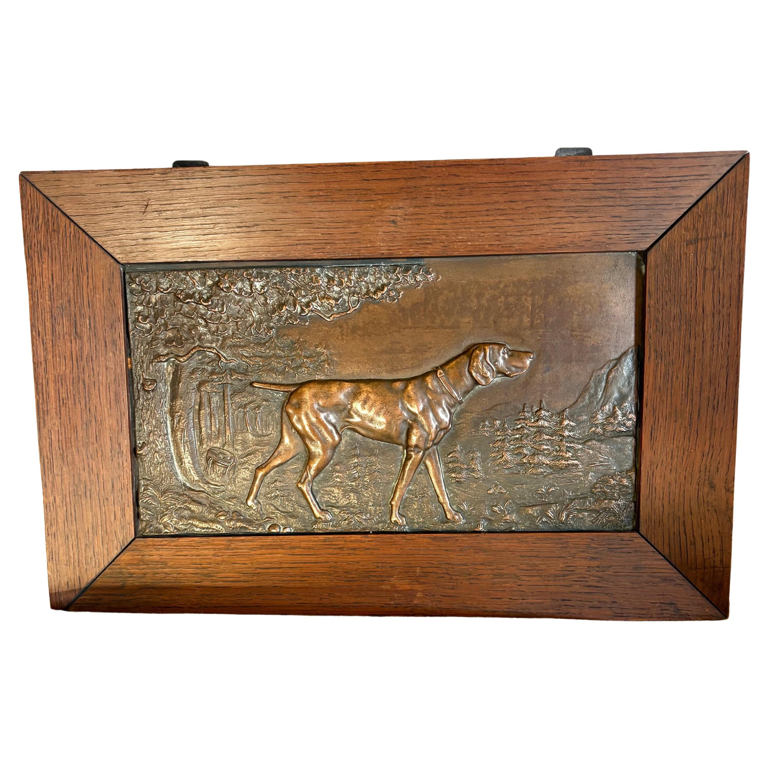 This Early 20th Century French Relief Plaque was handcrafted in the early 1900's by artisans in the Art Nouveau style. The piece is characterized by its flowing lines and natural motifs, depicting a hunting dog in an outdoor theme. Rectangular in