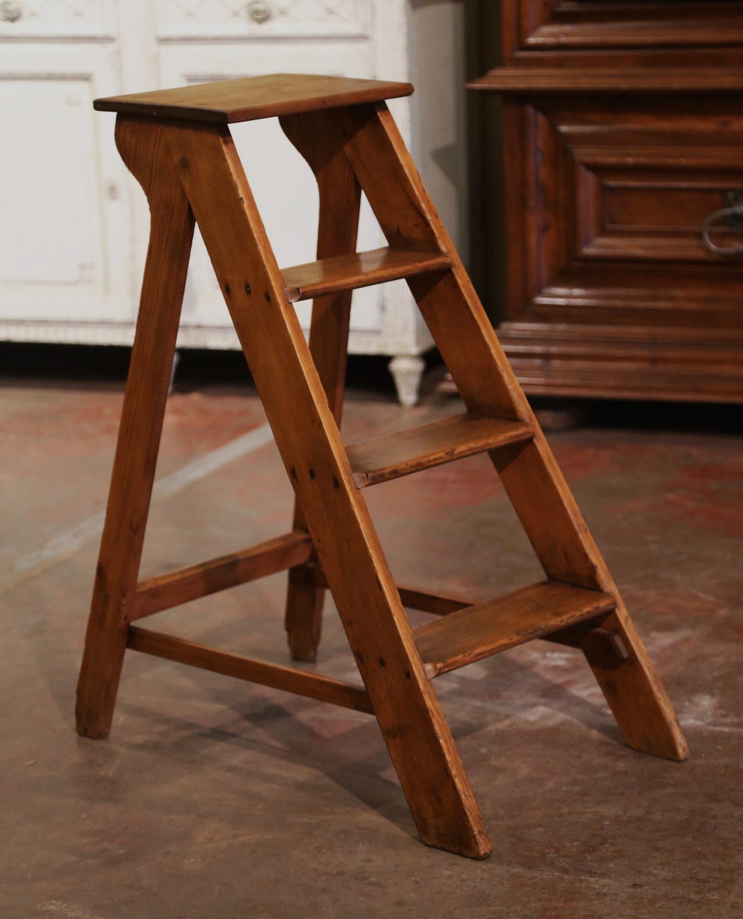 This elegant antique library ladder was created in Normandy France, circa 1920. Made of pine, the sturdy step ladder features four steps including a deeper step at the top. The small ladder is in excellent condition commensurate with age and use,