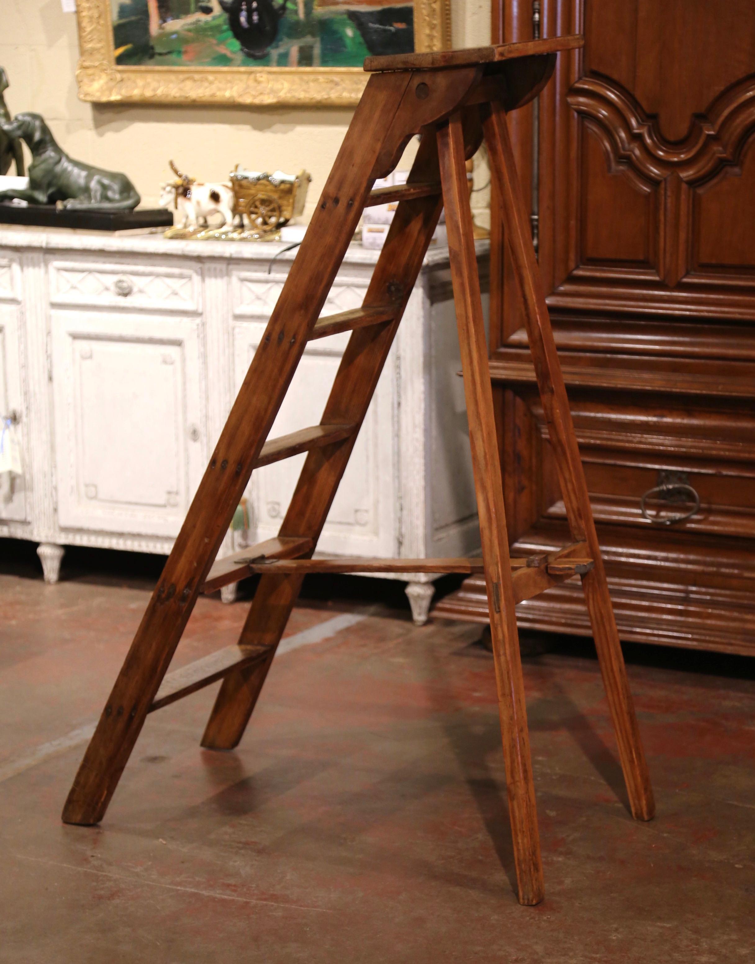 This elegant five foot antique library ladder was created in Normandy France, circa 1920. Made of pine, the sturdy step ladder features six steps including a wider and deeper step at the top. Practical and useful, the rustic ladder can be put away