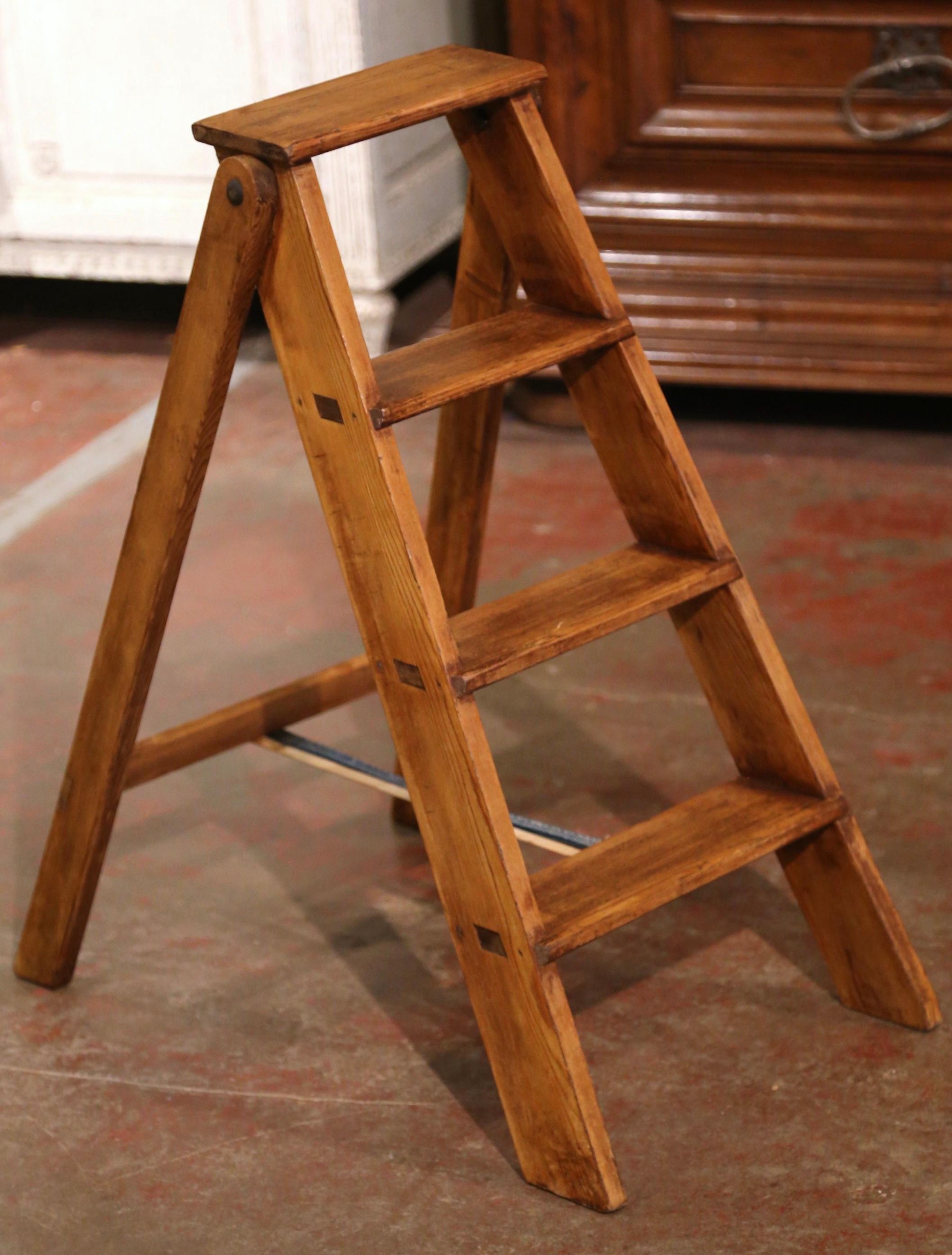 This elegant three foot antique library ladder was created in Normandy France, circa 1920. Made of pine, the sturdy step ladder features four steps including a deeper step at the top. Practical and useful, the rustic ladder can be put away by