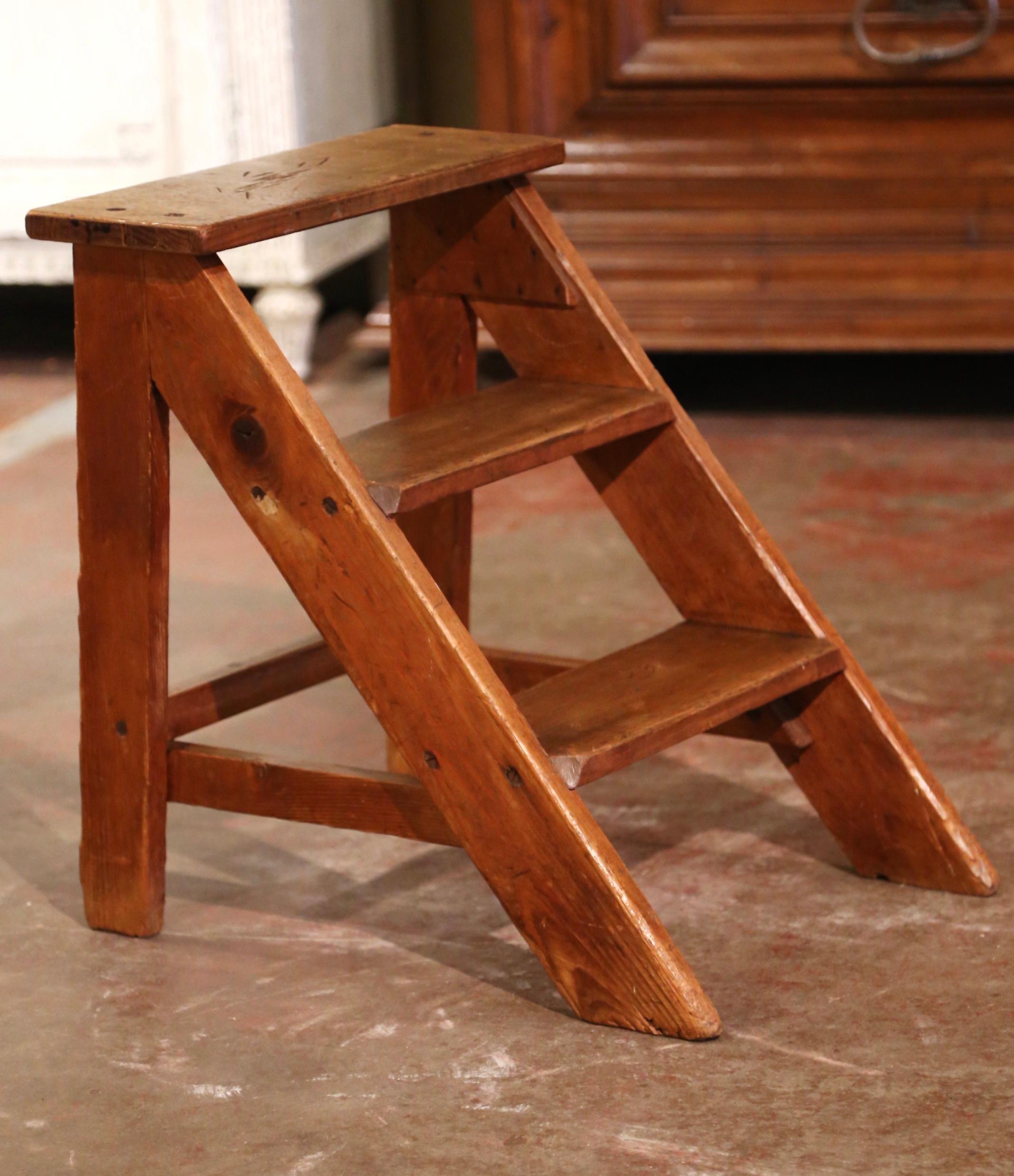 This elegant antique library ladder was created in Normandy France, circa 1920. Made of pine and oak, the sturdy step ladder features three steps including a wider step at the top. The small ladder is in excellent condition commensurate with age and