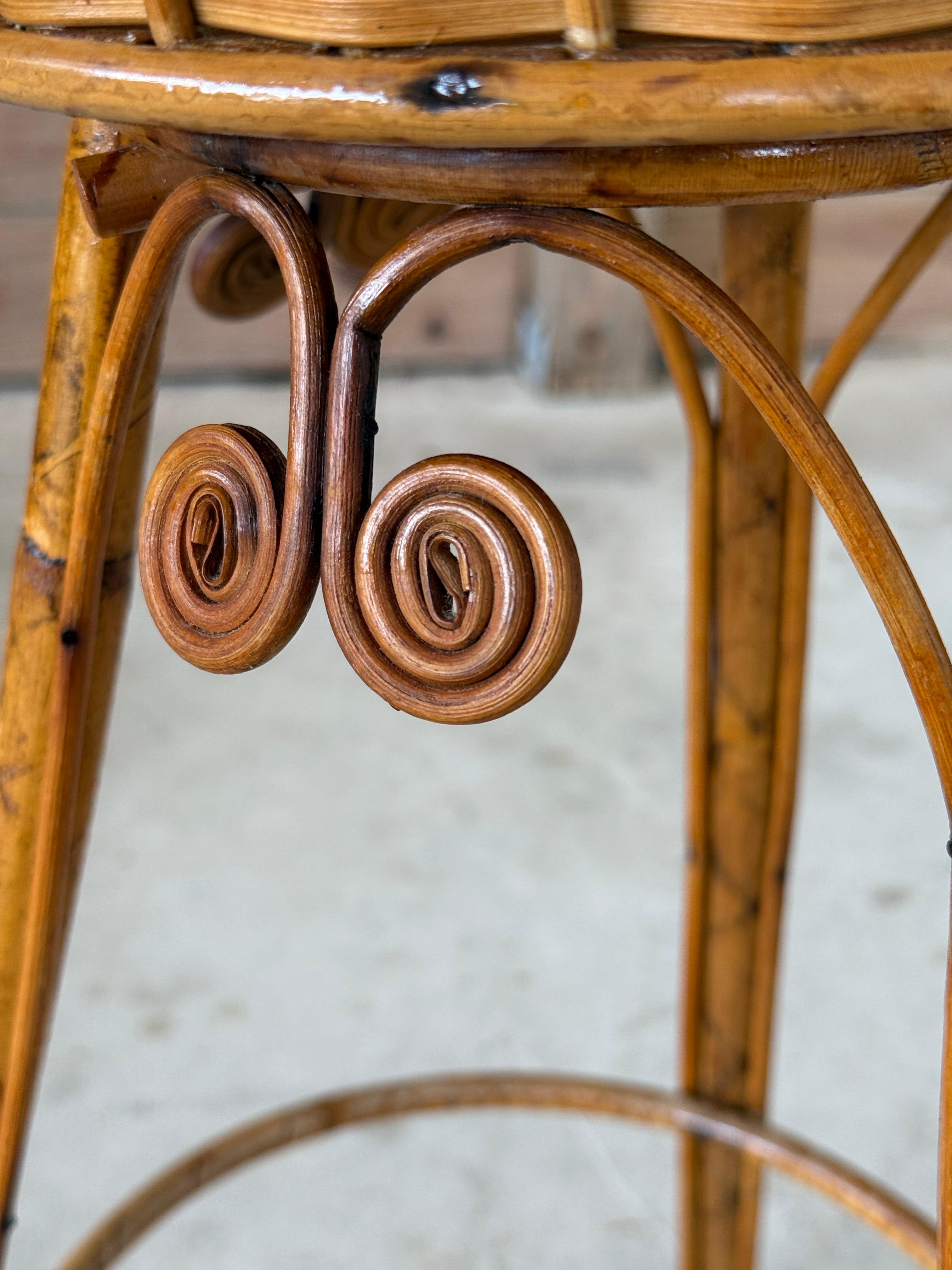 Grazioso cestino in rattan intrecciato a mano dell'inizio del XX secolo, elevato su un supporto a treppiede in rattan con volute decorative a forma di testa di violino. Il pezzo è dotato di un raro meccanismo girevole, realizzato in rattan, che
