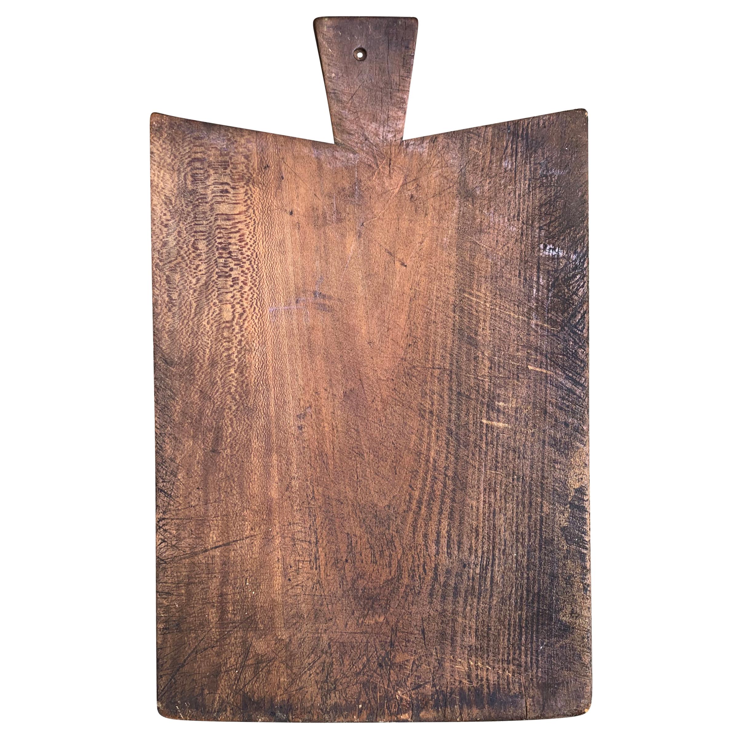 A wonderfully worn early 20th century French cutting board with a beautiful patina. All that’s missing is a selection of cheeses, charcuterie, and your guests.