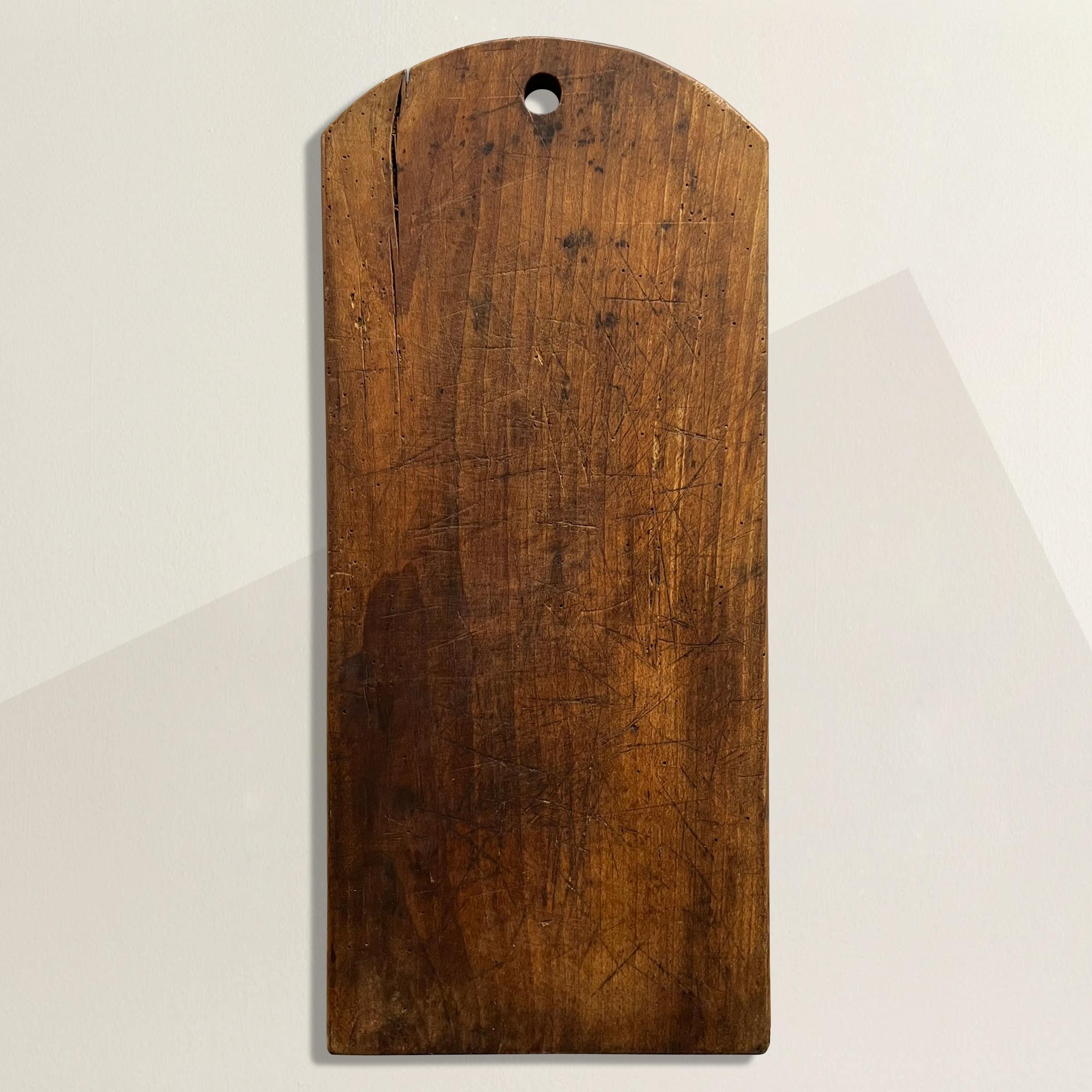 A wonderful early 20th century French cutting board with hundreds of knife marks and a patina that only time can bestow. Perfect for chopping vegetables and bread, or serving cheese and charcuterie at your next fête.