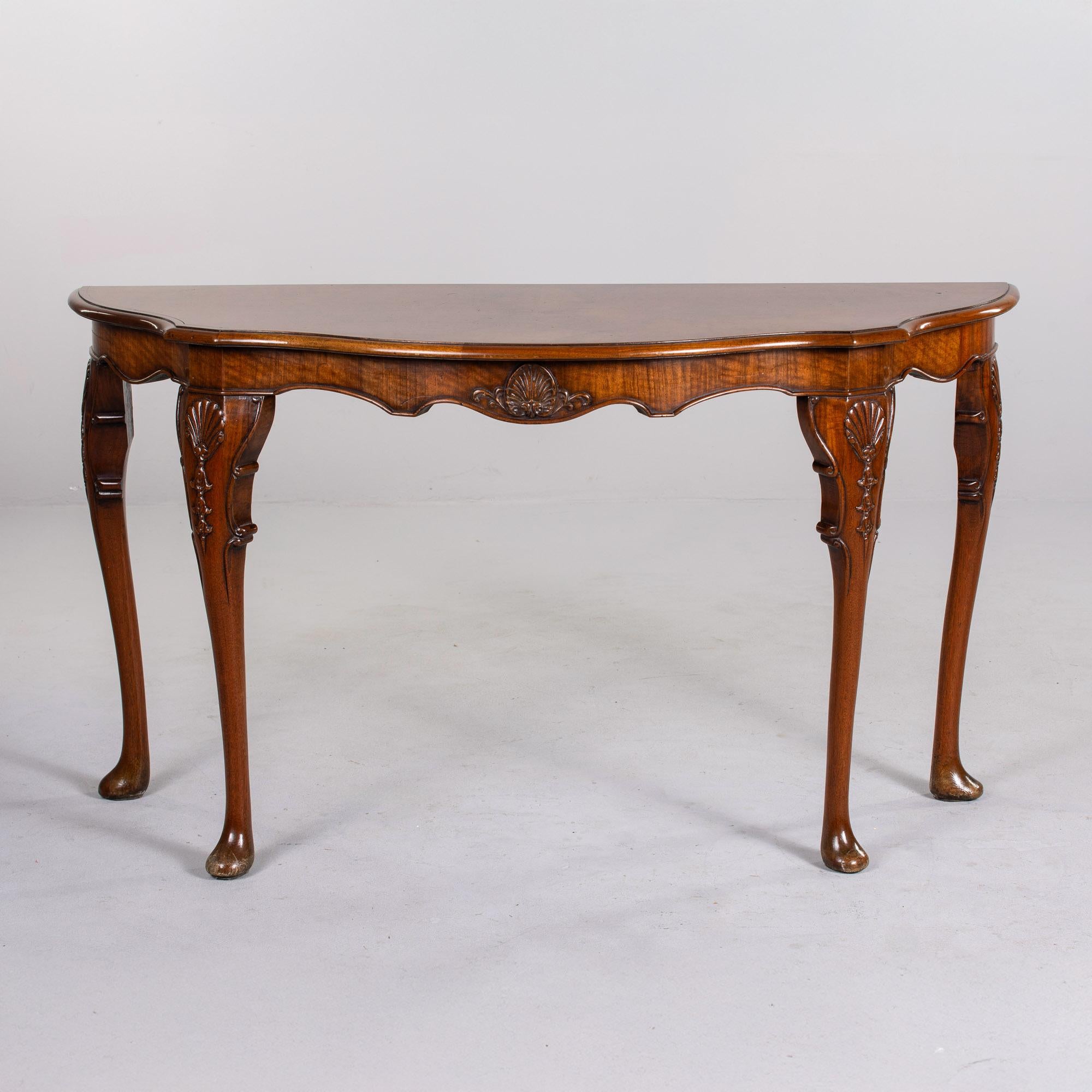 Trovata in Francia, questa console demilune risale al 1915 circa. Crediamo che si tratti di noce e impiallacciatura di noce. Le caratteristiche del tavolo includono l'impiallacciatura di radica con segnalibro sul piano del tavolo, decorazioni