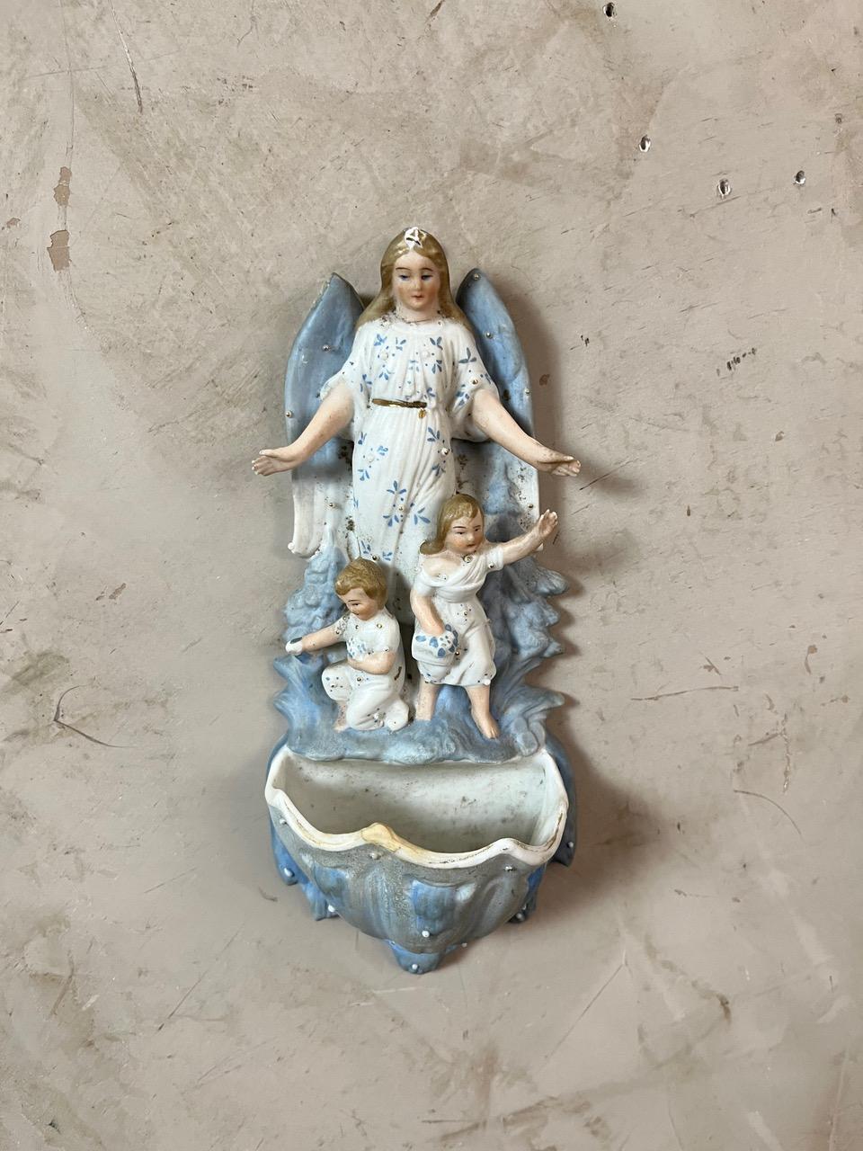 Ancien bénitier en faïence (biscuit) - Ange gardien avec enfants, Circa 1900

Ajoutez une touche de charme spirituel à votre intérieur avec ce délicat bénitier ancien, réalisé en porcelaine biscuitée vers 1900. La pièce représente un ange gardien