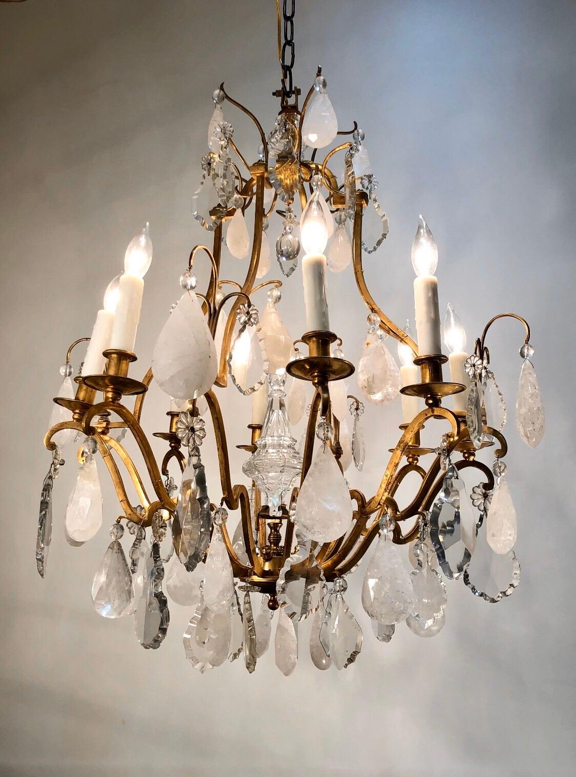 Elegant French LXV style bronze and rock crystal eight light chandelier. This chandelier has wonderful heavy handcut rock crystal prisms suspended from a Classic gilt bronze bird cage frame with eight candle arms.