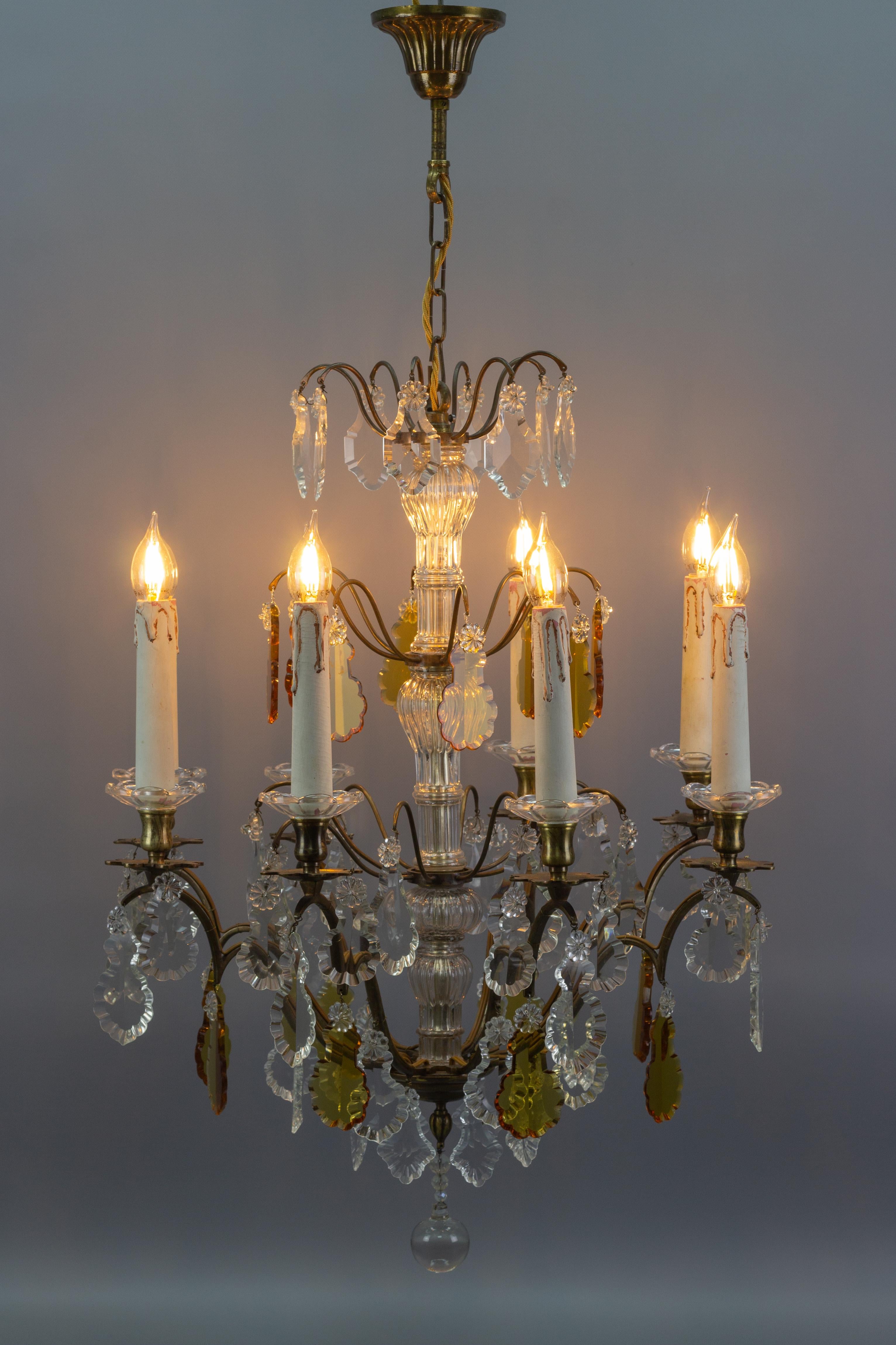Superbe lustre de style Louis XVI en verre de cristal et laiton, fabriqué en France vers les années 1900. Conçu à l'origine pour 8 bougies, ce lustre ancien a été électrifié. Huit bras en laiton avec des bouchons en laiton et en verre en forme de