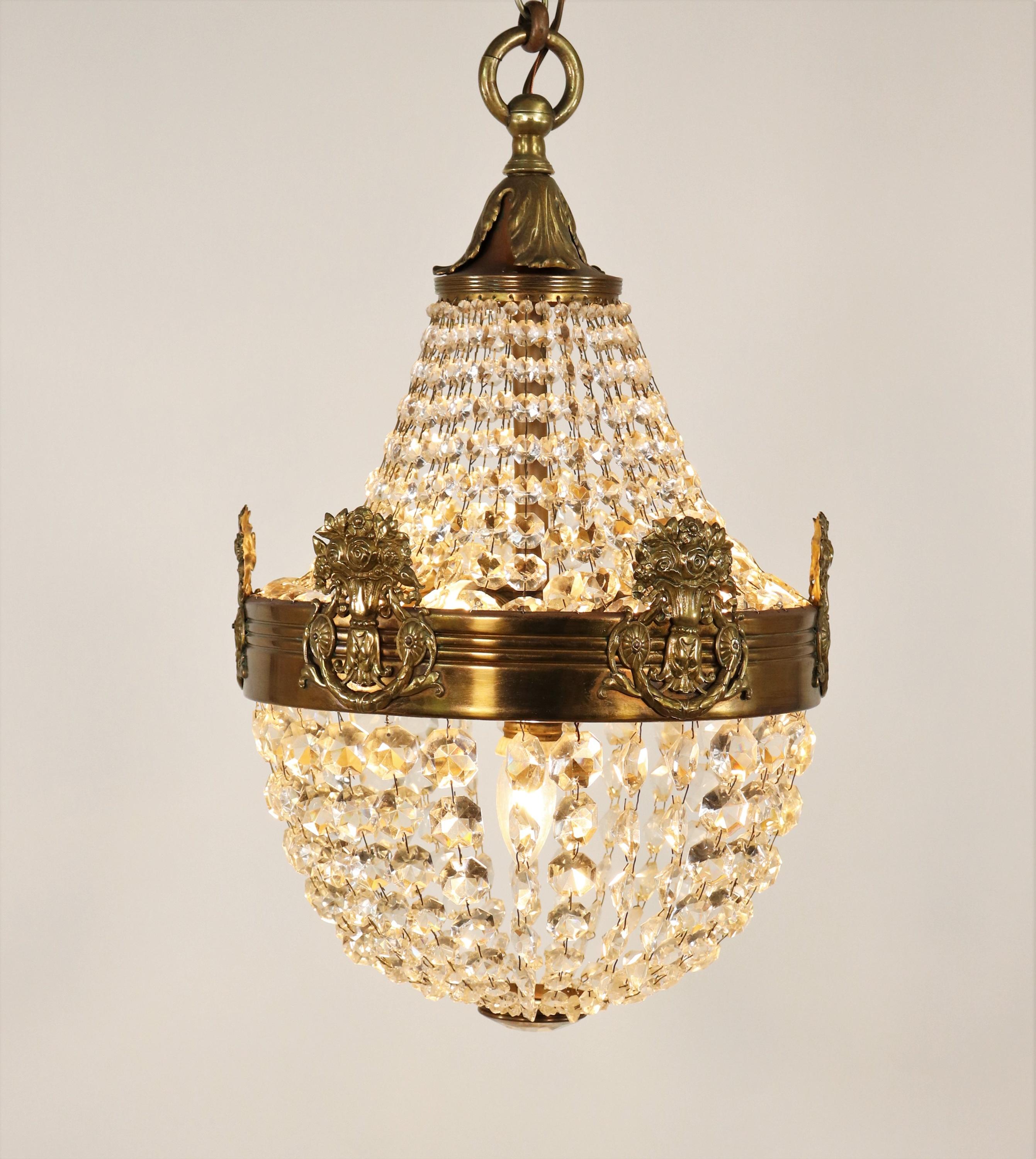 Questo lampadario in stile Impero francese del 1930 circa è realizzato in ottone e cristallo. Caratterizzato dal tradizionale design a 