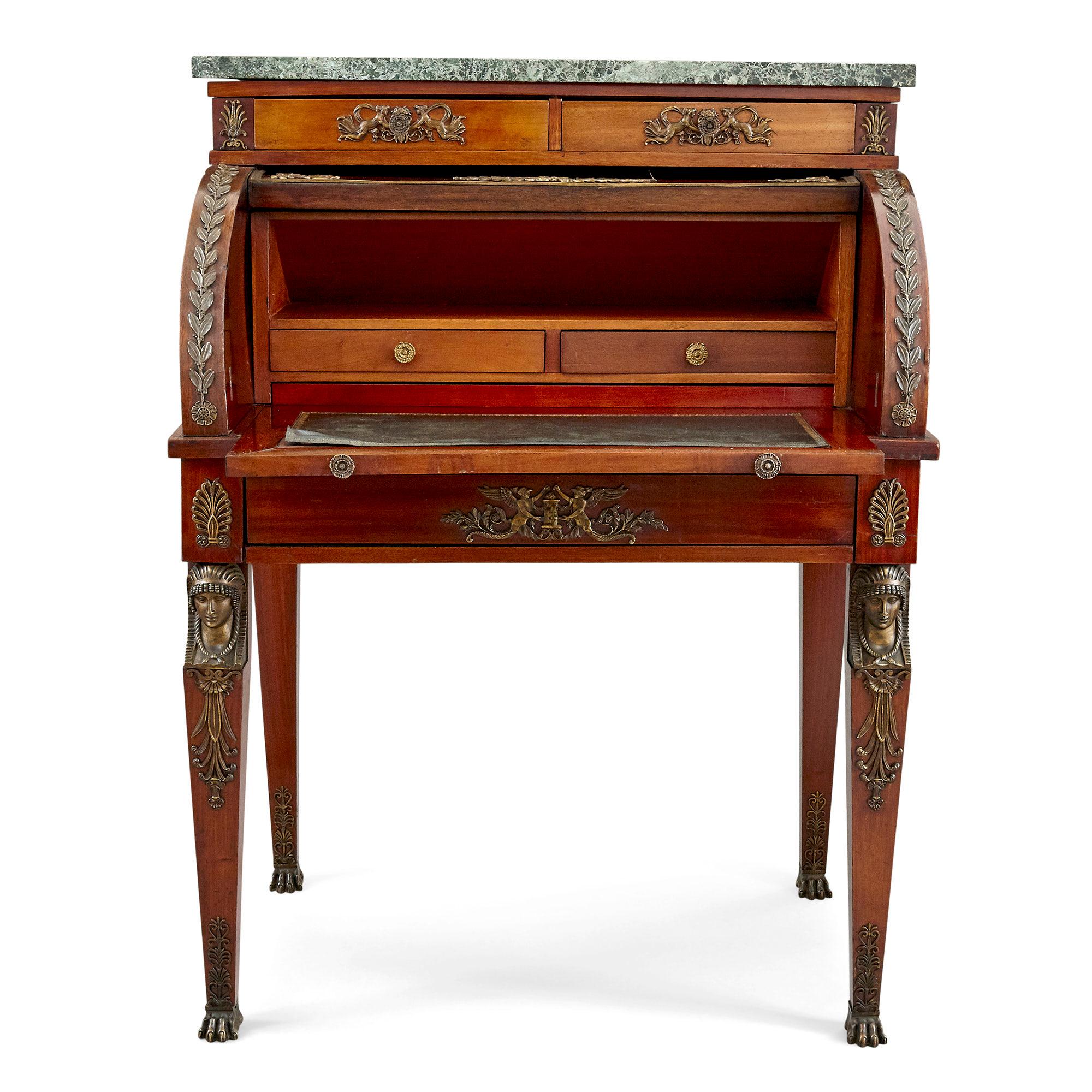 Early 20th century French Empire style roll-top desk
French, early 20th century
Dimensions: Height 113cm, width 84cm, depth 62cm

This charming roll-top desk is crafted from ormolu mounted hardwood, with a grey-green marble top and leather