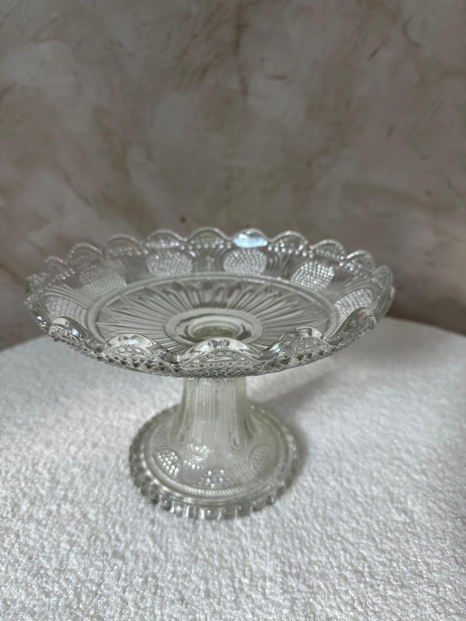 Clear pressed glass compote with molded and etched decorative details on the base and along the scalloped rim. The slightly wavy edge adds an elegant touch, making it easy to display on a dining table or in a cabinet.
Perfect for serving fruit,
