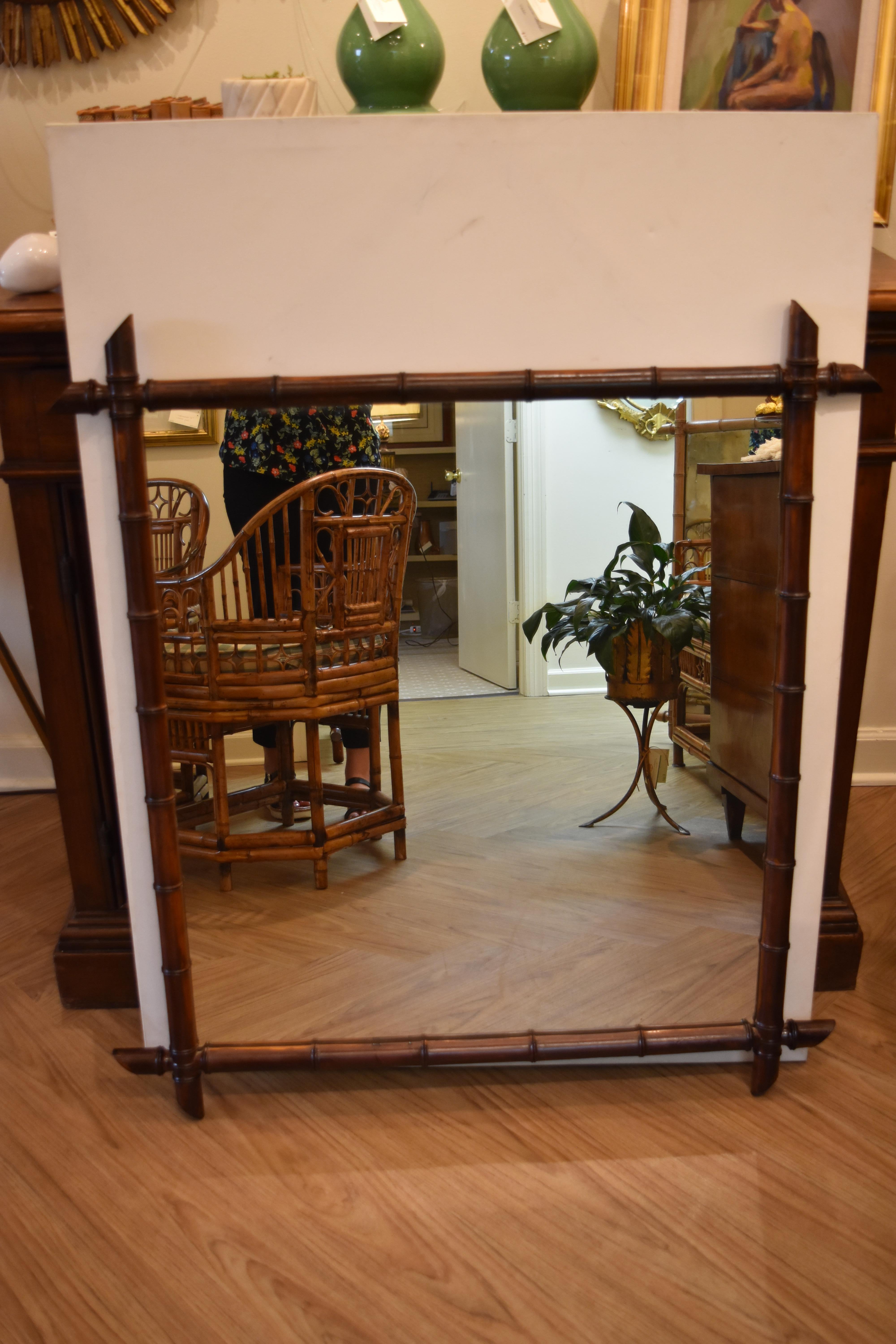 This early 20th century French faux bamboo mirror features a warm brown finish with intersecting corners. As can be seen from the photos, it appears to have the original back and would make a wonderful addition to any room.