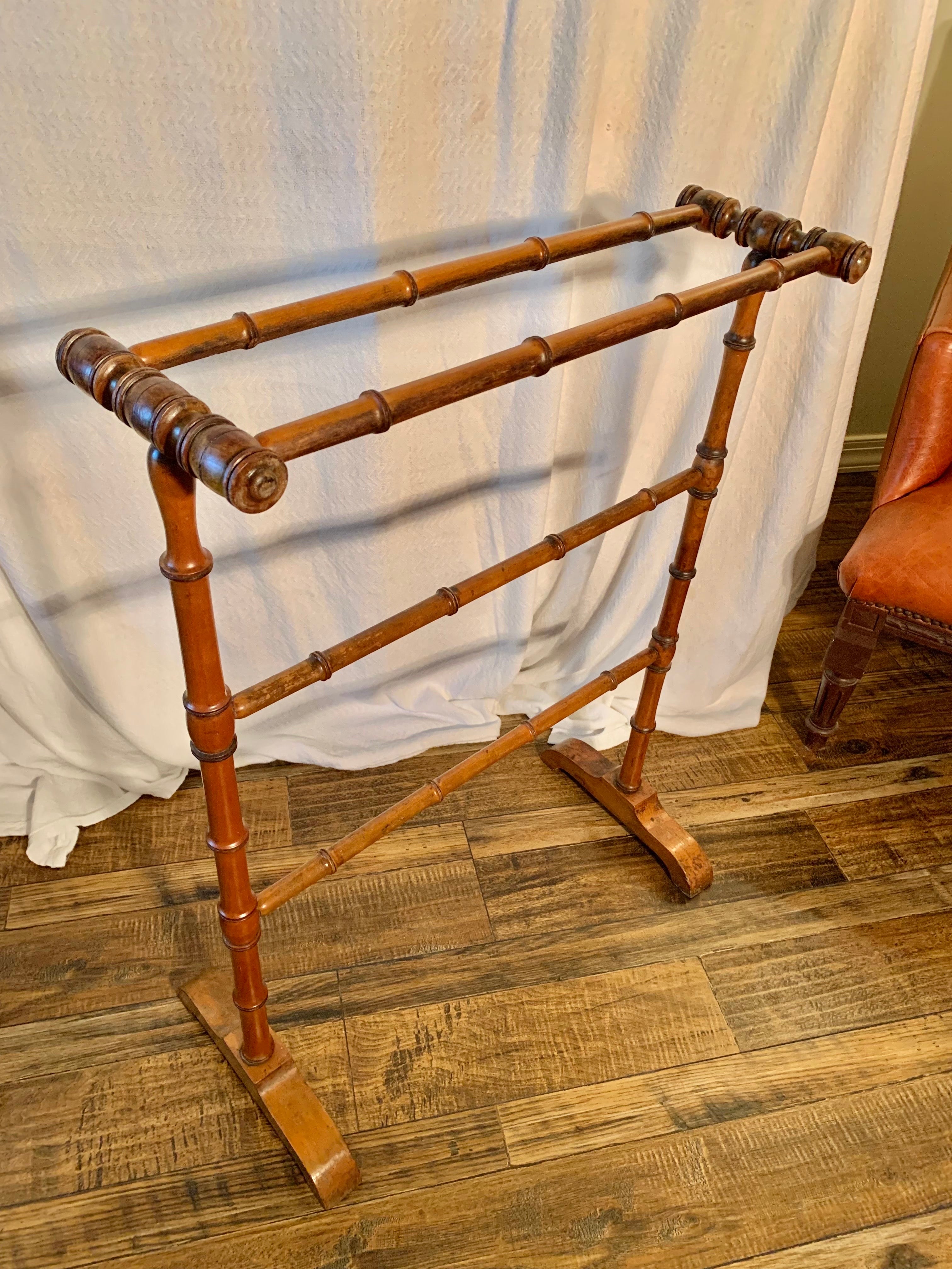 Found in the South of France, this Early 20th Century Towel Rack or Quilt Stand was handcrafted in the Faux Bamboo Style by French artisans in the early 1900's. The piece features four hand carved hanging bars, two top and two center which also