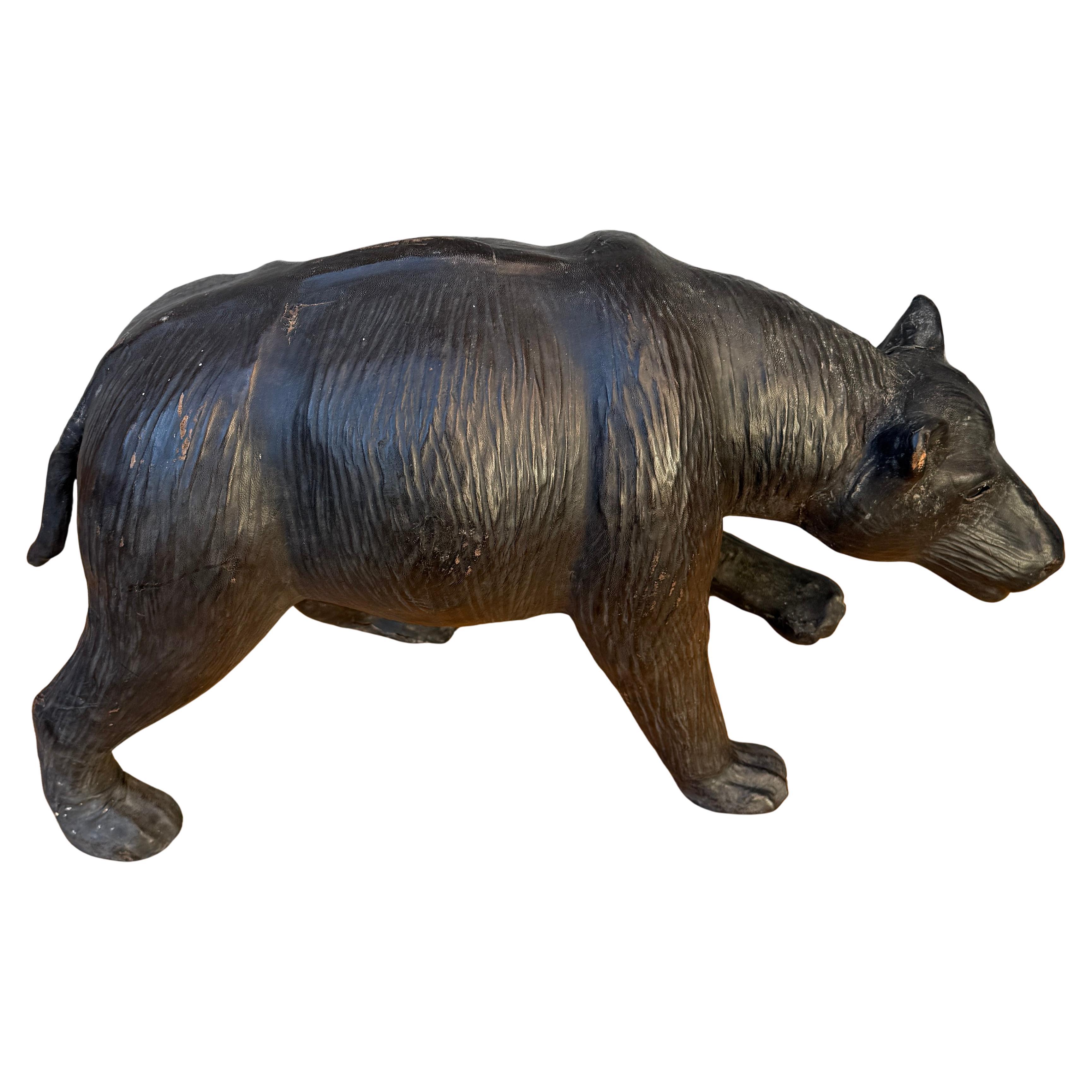 Sculpture d'art populaire représentant un ours, réalisée à la main, datant de la première partie du XXe siècle. Cet ours en papier mâché est enveloppé de cuir et présenté dans son authentique patine d'origine. Cette œuvre d'art représente l'un des