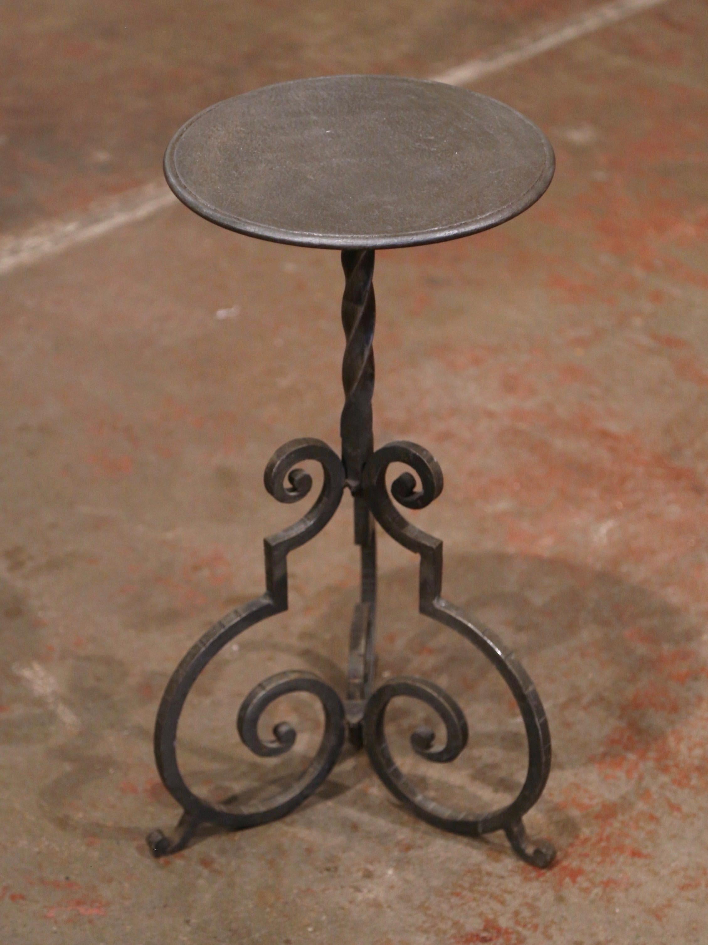 This elegant, antique Gothic pedestal table was crafted in Southern France, circa 1920. The intricate martini table features a forged central twisted pedestal stem embellished over three scroll feet. The petite table is topped with a round surface