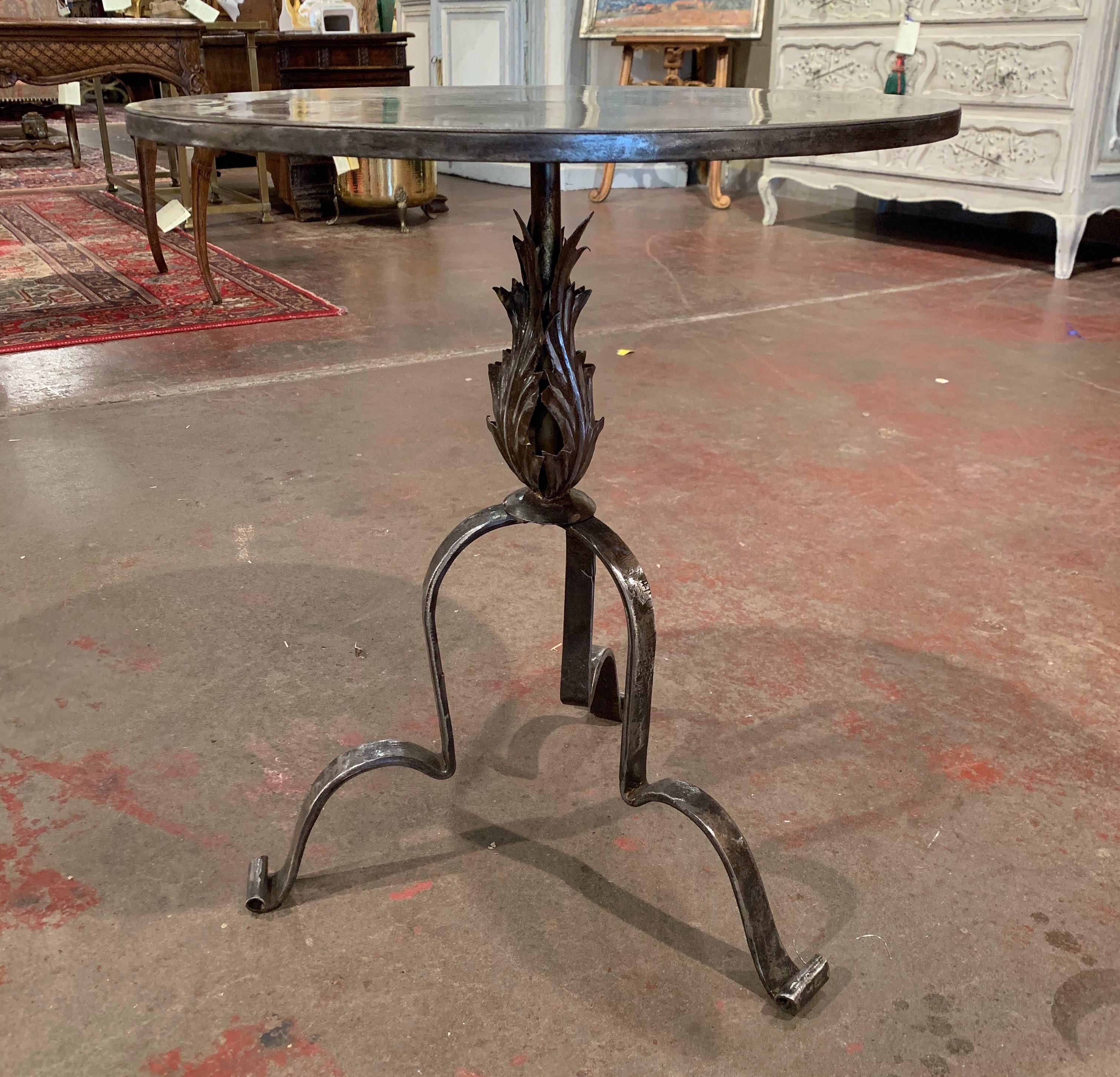 This elegant, antique Gothic pedestal table was crafted in Southern France, circa 1920. The intricate martini table stands on three forged feet over a central pedestal stem embellished with acanthus leaf motifs. The serving table is topped with a