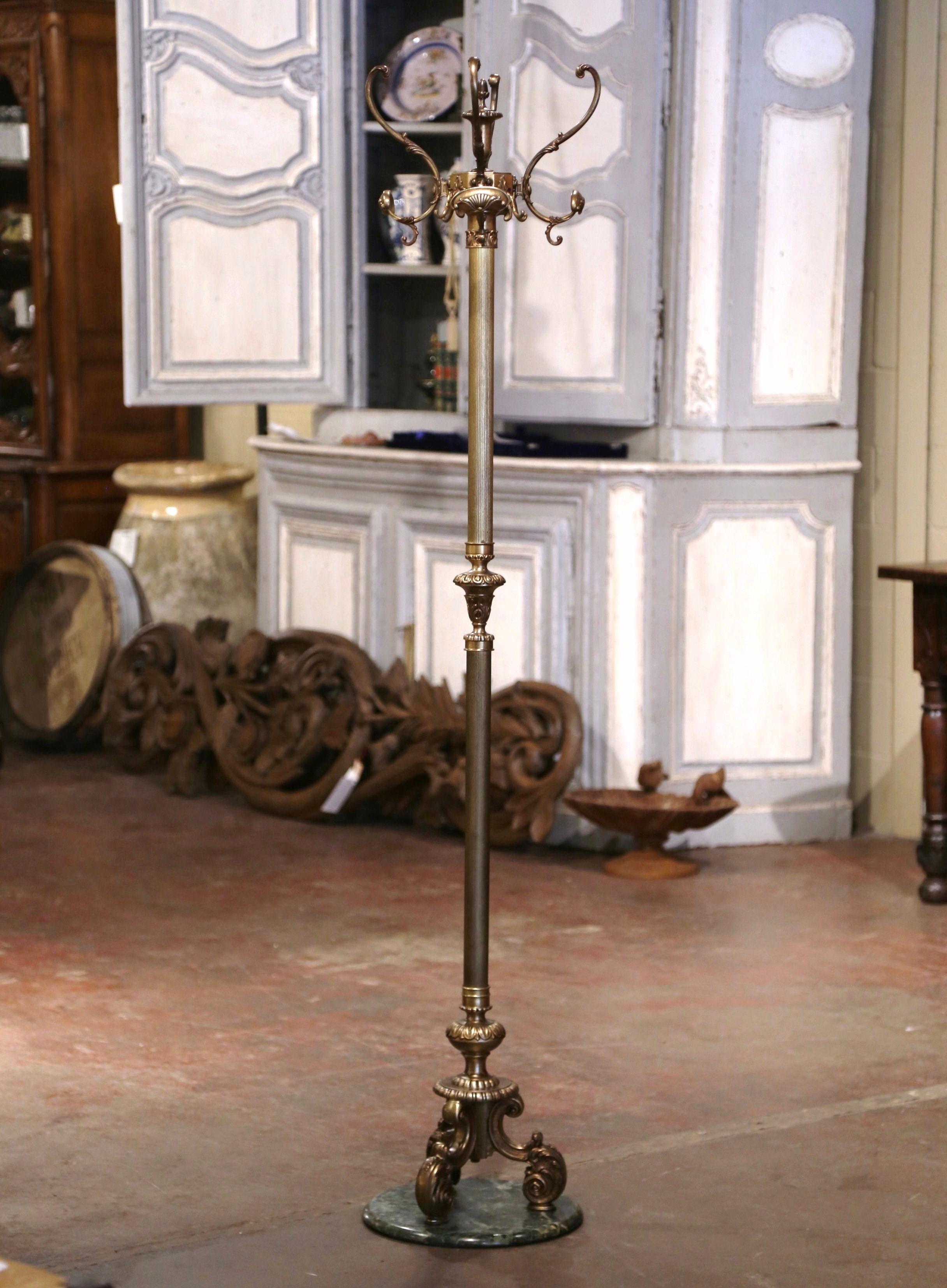 Questo antico albero a stelo in ottone e metallo è stato realizzato in Francia, intorno al 1920. Poggiato su un piede tripartito e su una base in marmo che termina con piedi a voluta, l'alto scaffale presenta un gambo centrale scanalato impreziosito