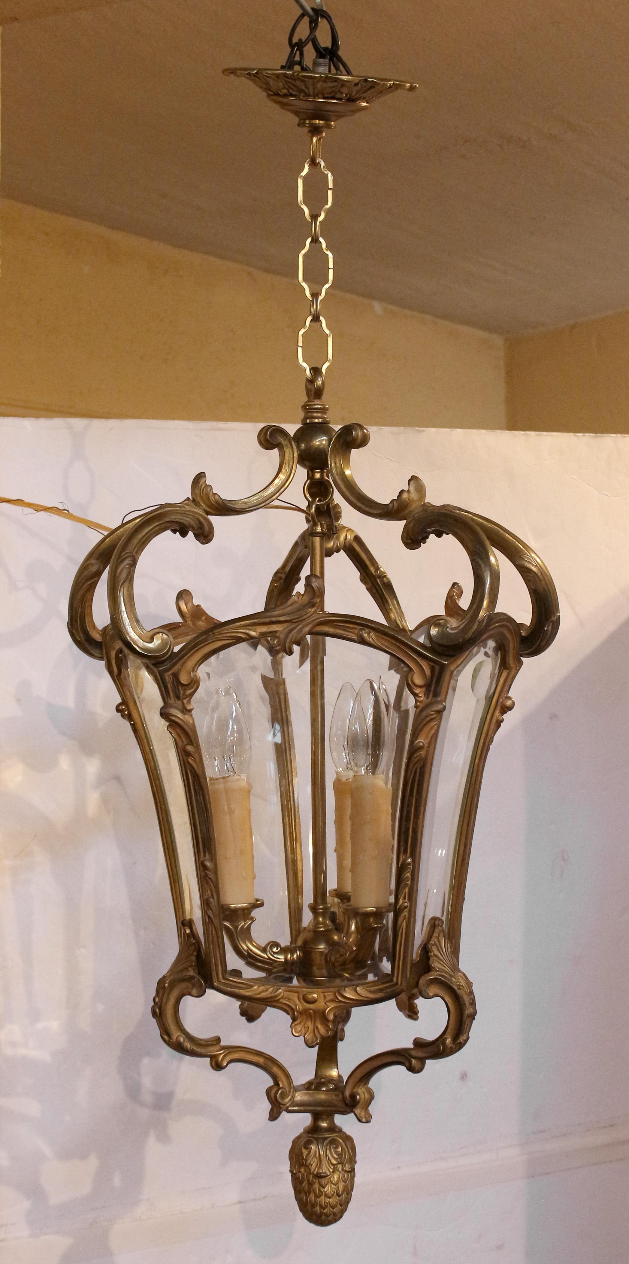Early 20th century gilt bronze & glass hall lantern, French. In the baroque to rococo transitional taste. Pineapple drop symbolizing 