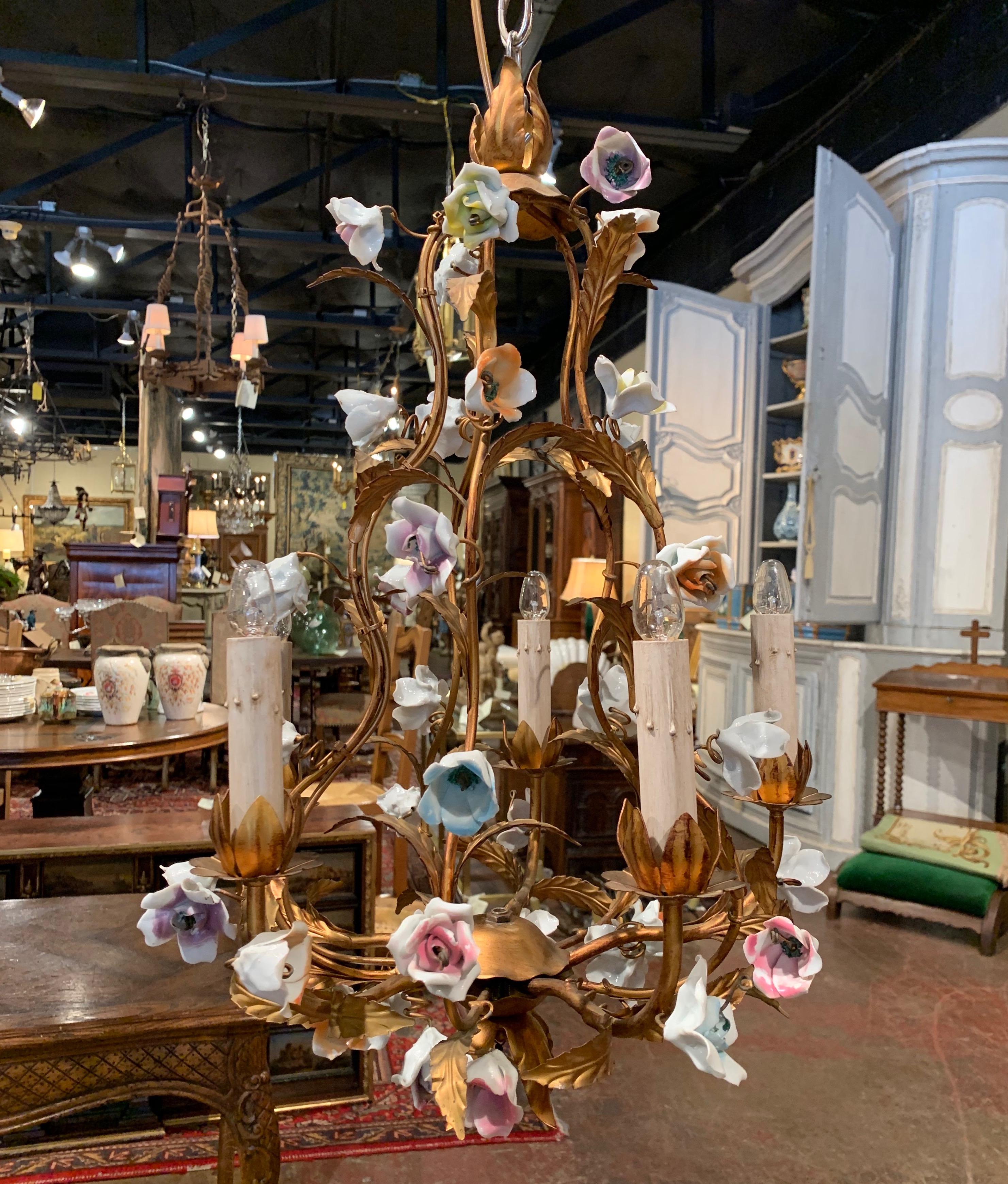 Decorate an entryway or powder room with this elegant and feminine light fixture. Crafted in France circa 1920, the petite, antique chandelier is decorated with colorful porcelain flowers and gilt painted leaves. The five-light chandelier has new
