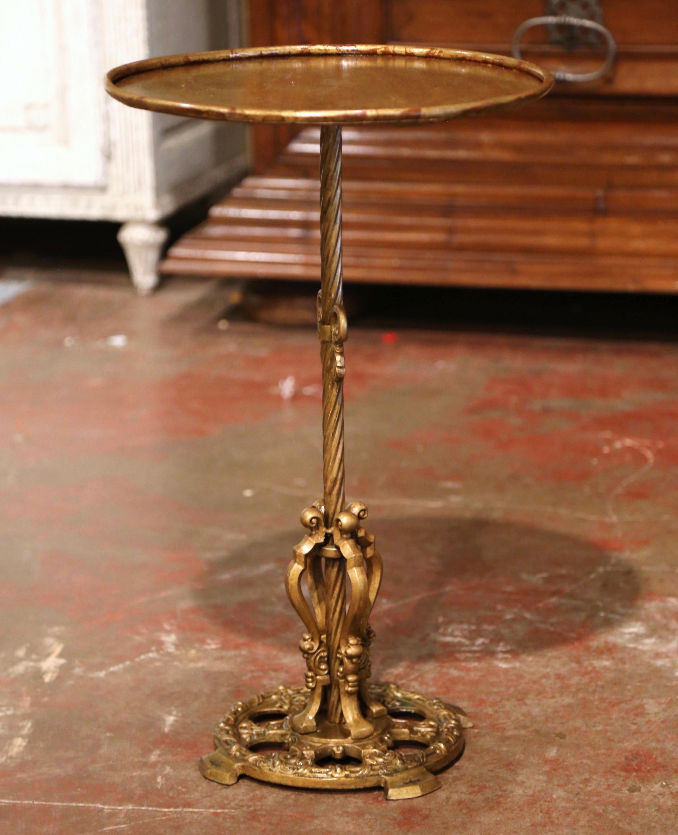 This elegant, antique pedestal table was crafted in Southern France, circa 1920. The martini table features a forged central pedestal stem embellished with a central decor, over an intricate flat round base decorated with leaf motifs. The serving