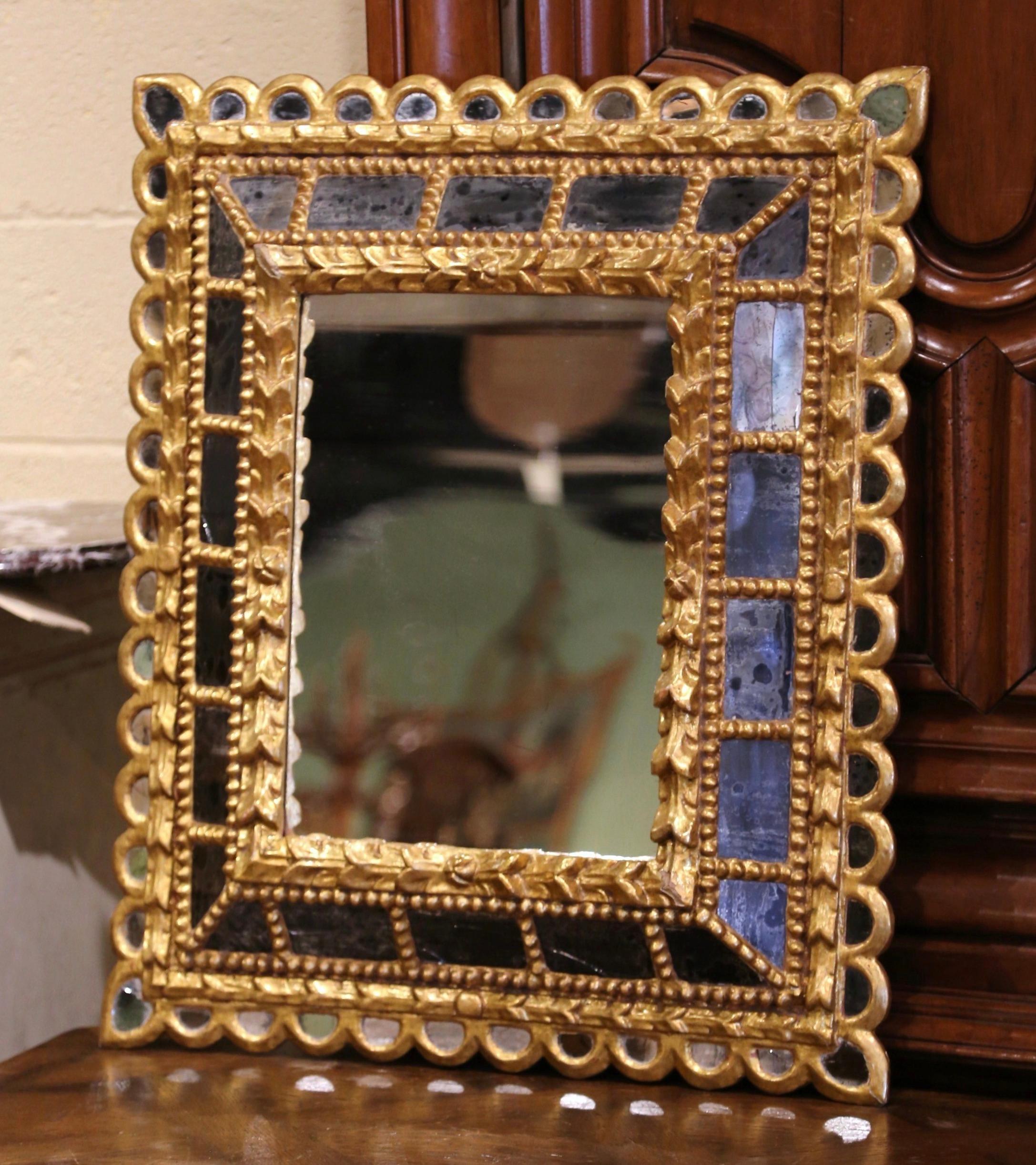 This elegant vintage sun mirror was crafted in France, circa 1920. Rectangular in shape the large antique wall mirror features a raised center mirror with mercury glass set inside a carved frame; the four sides are decorated with small overlay