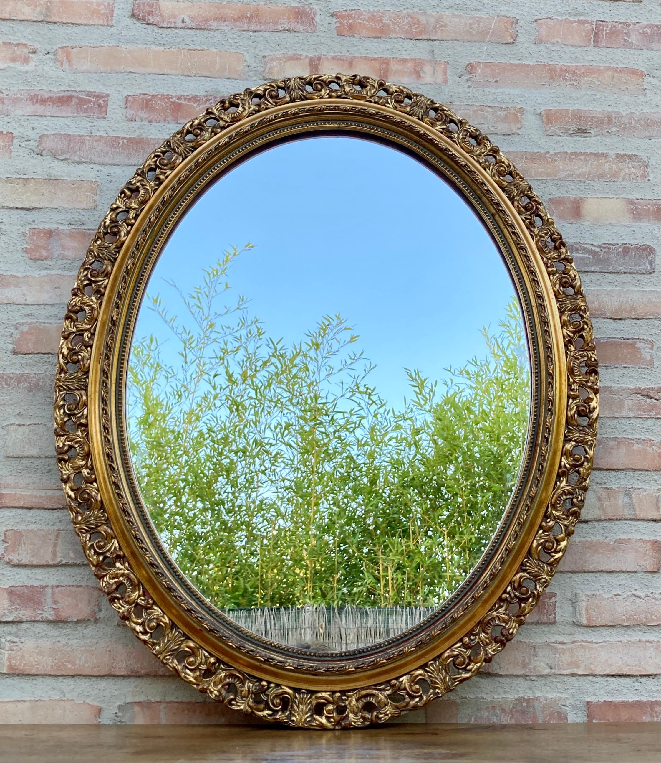 A magnificent oval shaped gold mirror, which has a mirror in perfect condition for use.
Its beautifully carved gilt wood frame with beads and gadroon with a central floral ridge surrounding the entire frame. This antique wall mirror retains its