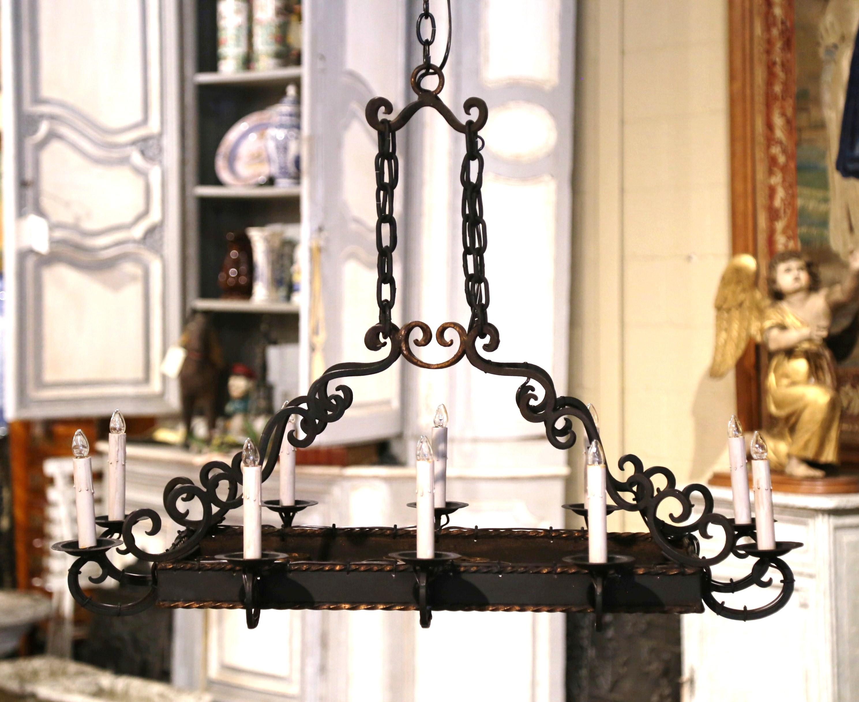Decorate a kitchen island or breakfast room with this elegant antique light fixture. Forged in France circa 1920, and rectangular in shape, the large chandelier has ten lights newly wired, and dressed with decorative dripping candle sleeve covers.