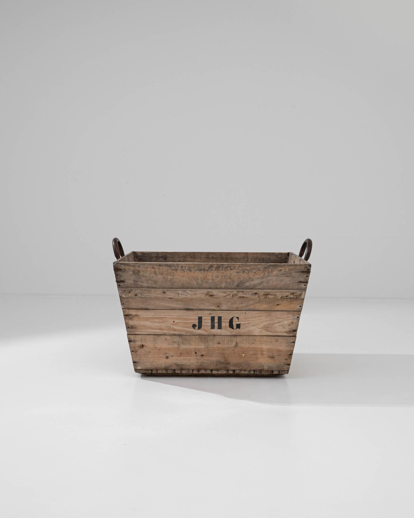 A tangible artifact of the past, this antique grape crate reflects the authentic practices of winemaking and grape harvesting in early 20th-century France. Equipped with sturdy metal handles, the crate features a practical rectangular shape with the