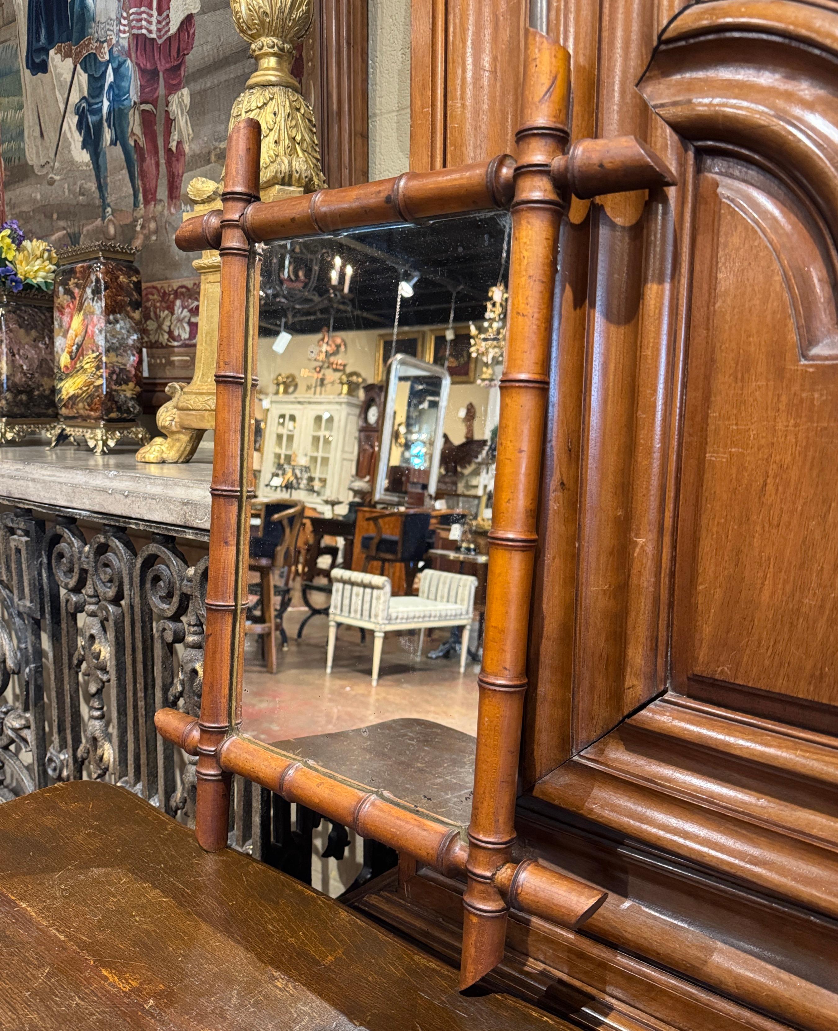 Decora un corridoio o una toilette con questo incantevole specchio antico in legno tornito a fuso. Realizzata in Francia intorno al 1920, questa decorazione da parete è caratterizzata da una lavorazione semplice ma elegante. La struttura in noce è