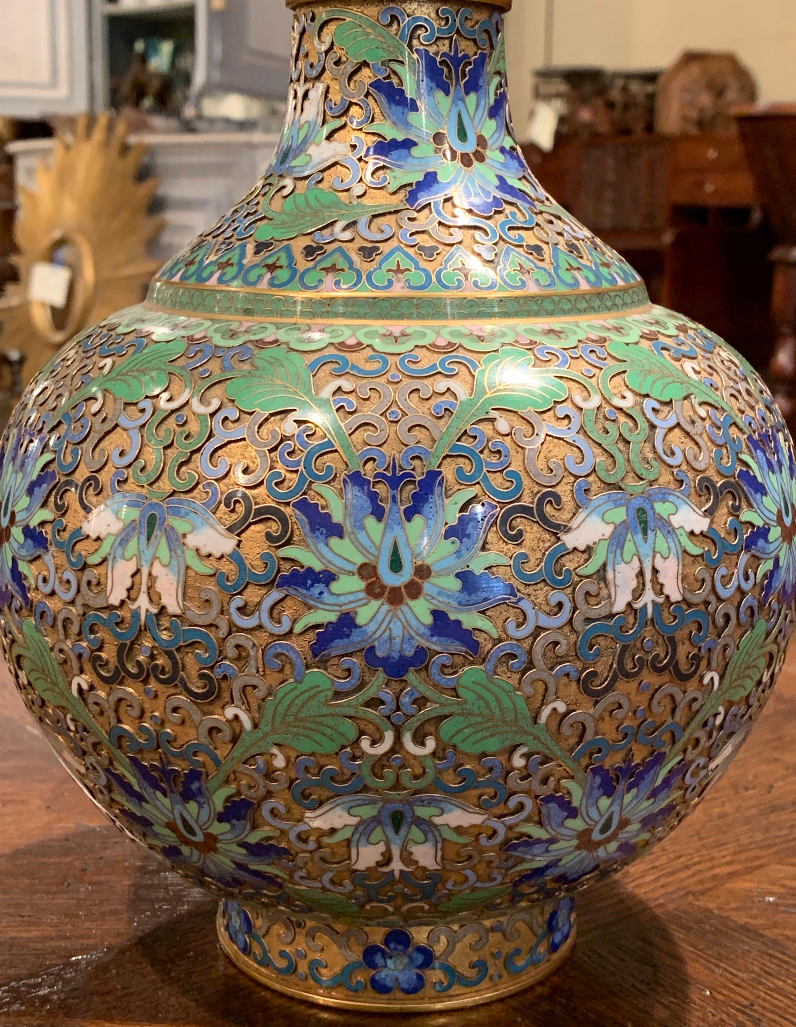 Display this imported Chinese cloisonne vase on a mantel or convert it to a table lamp for the perfect chinoiserie accessory in your home. Crafted in France circa 1920, the colorful piece shows exceptional cloisonne technique with traditional floral