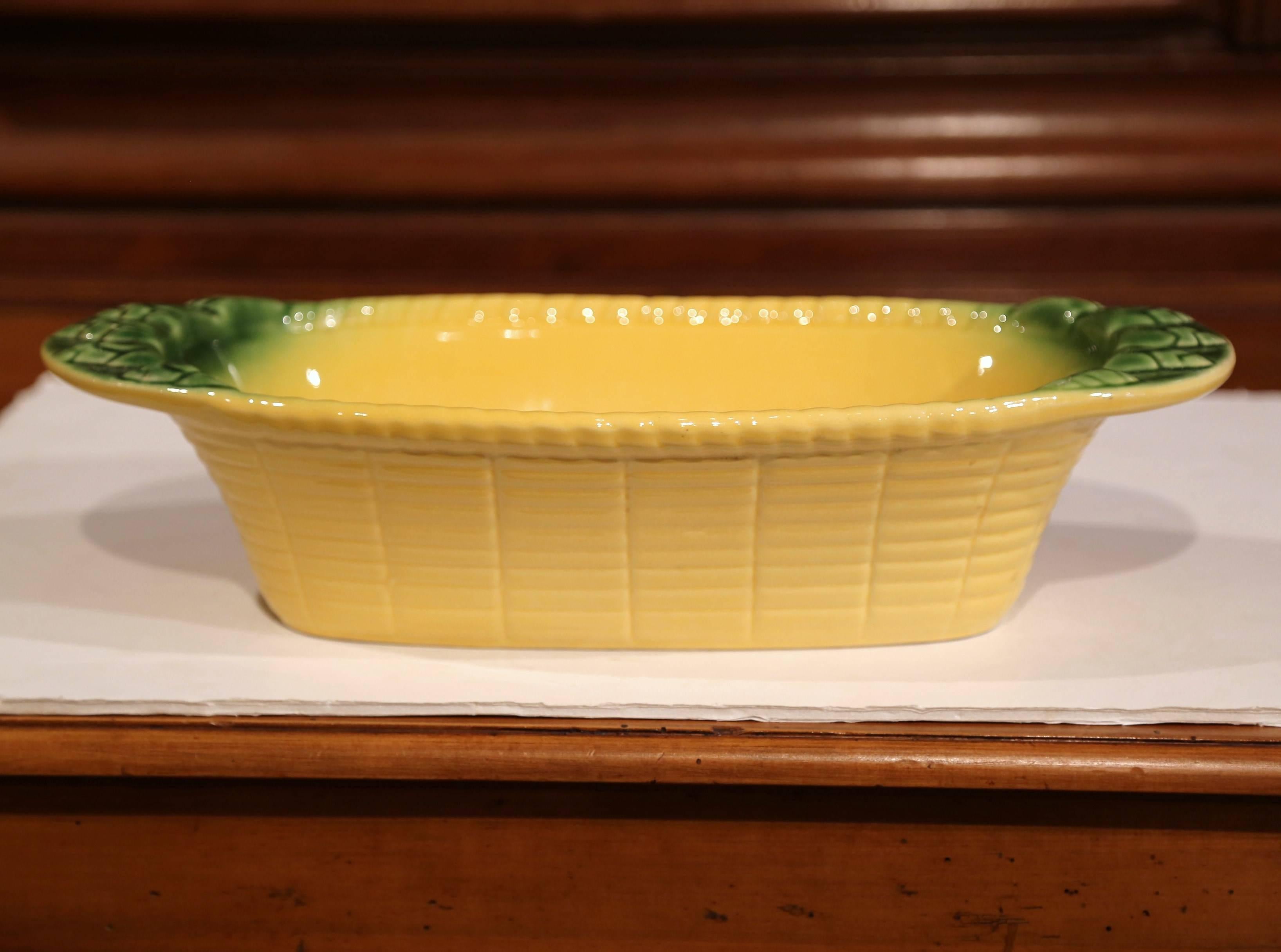 Display your fruit or other perishables in this colorful antique Majolica dish. Created in Provence, France crafted, circa 1920, the decorative porcelain bowl resembles an ear of corn and features a woven basket motif with decorative green handles