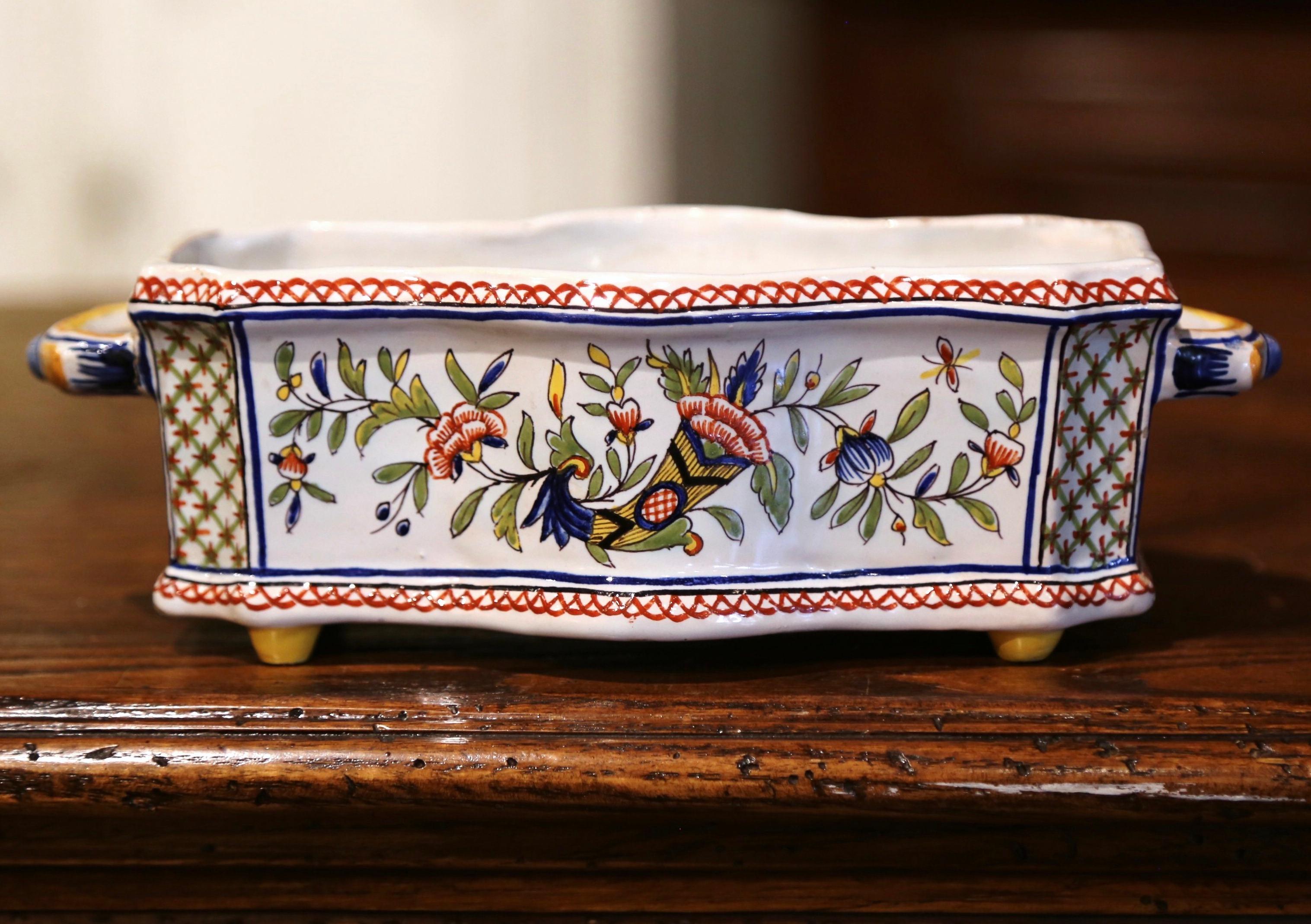 Decorate a mantle, table or buffet with this colorful antique planter. Sculpted in Normandy, France circa 1920, and rectangular in shape, the ceramic jardiniere stands on small feet and is dressed with side handles; it features a playful bombe and