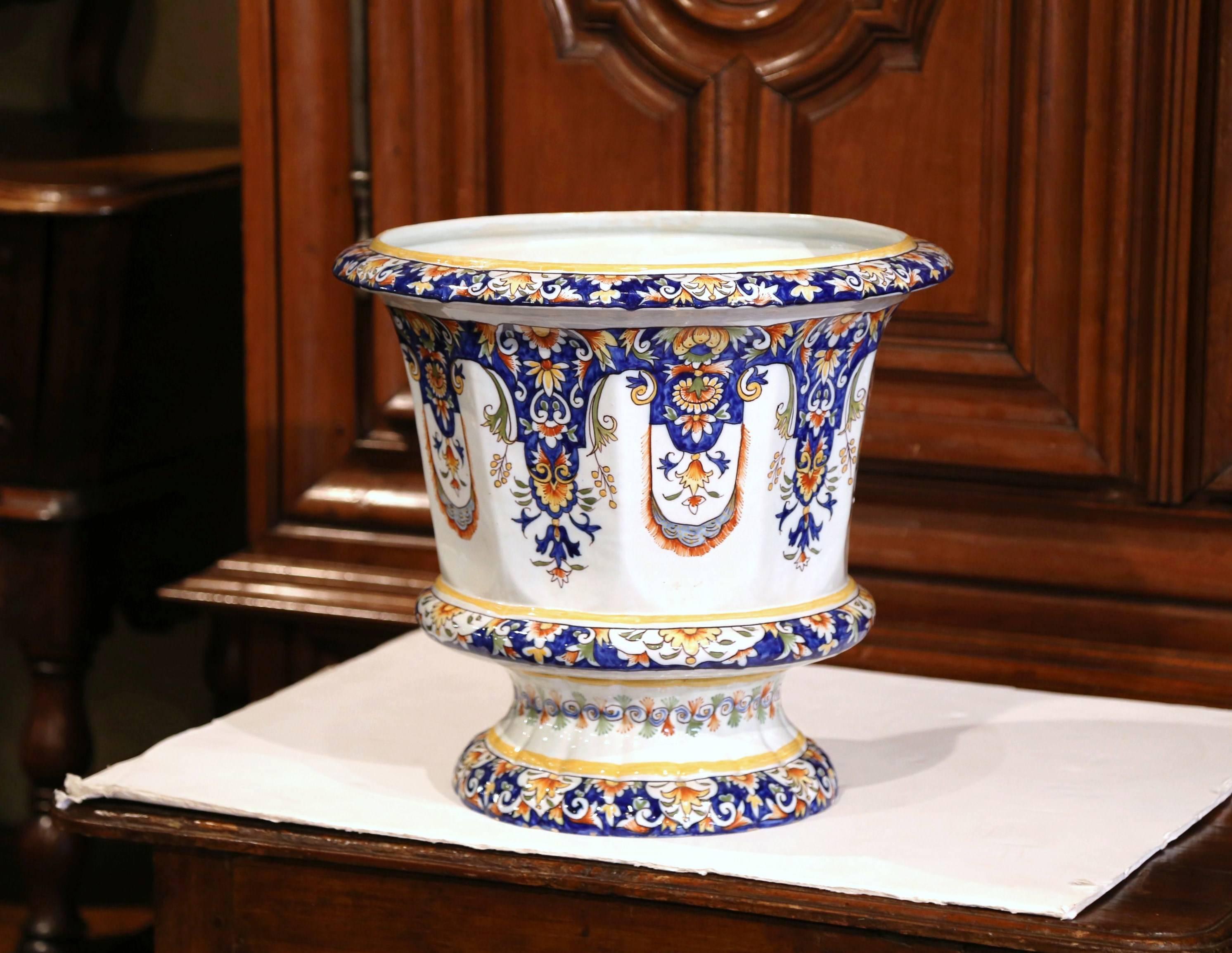 This elegant, large antique ceramic cachepot was crafted in Normandy, France, circa 1920. Signed on the bottom Rouen, the Classic, colorful planter features hand painted decorative floral and leaf motifs in a blue, orange, white and yellow palette.