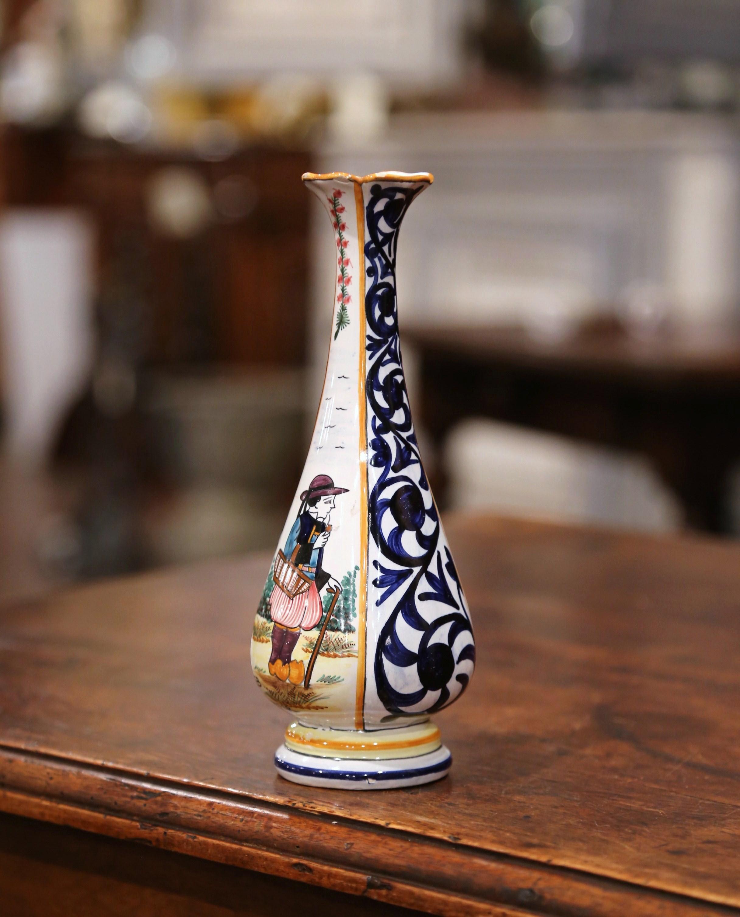 Decorate a shelf with this colorful hand painted flower vase. Created in Brittany, France, circa 1950, the small ceramic vessel is decorated on the front with a Breton man in traditional costumes coming back from the fields, and is embellished with