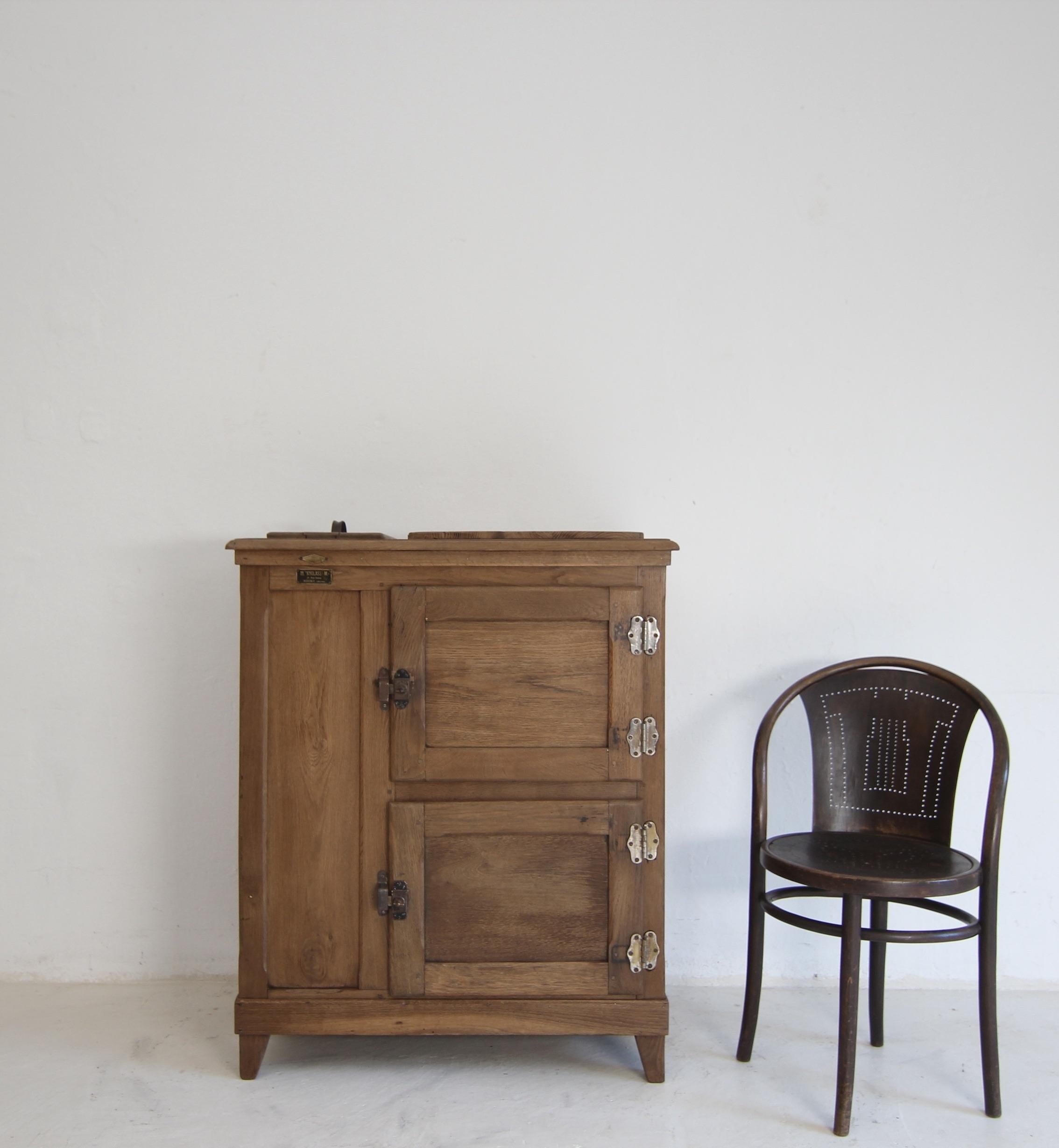 Glacière française du début du 20e siècle. Fabricant : M. 'KYGLASS' M. Reims. Remis à neuf et prêt à l'emploi.

Armoire rectangulaire en chêne aux côtés moulurés et au plateau profilé légèrement en saillie. Deux portes superposées sur charnières