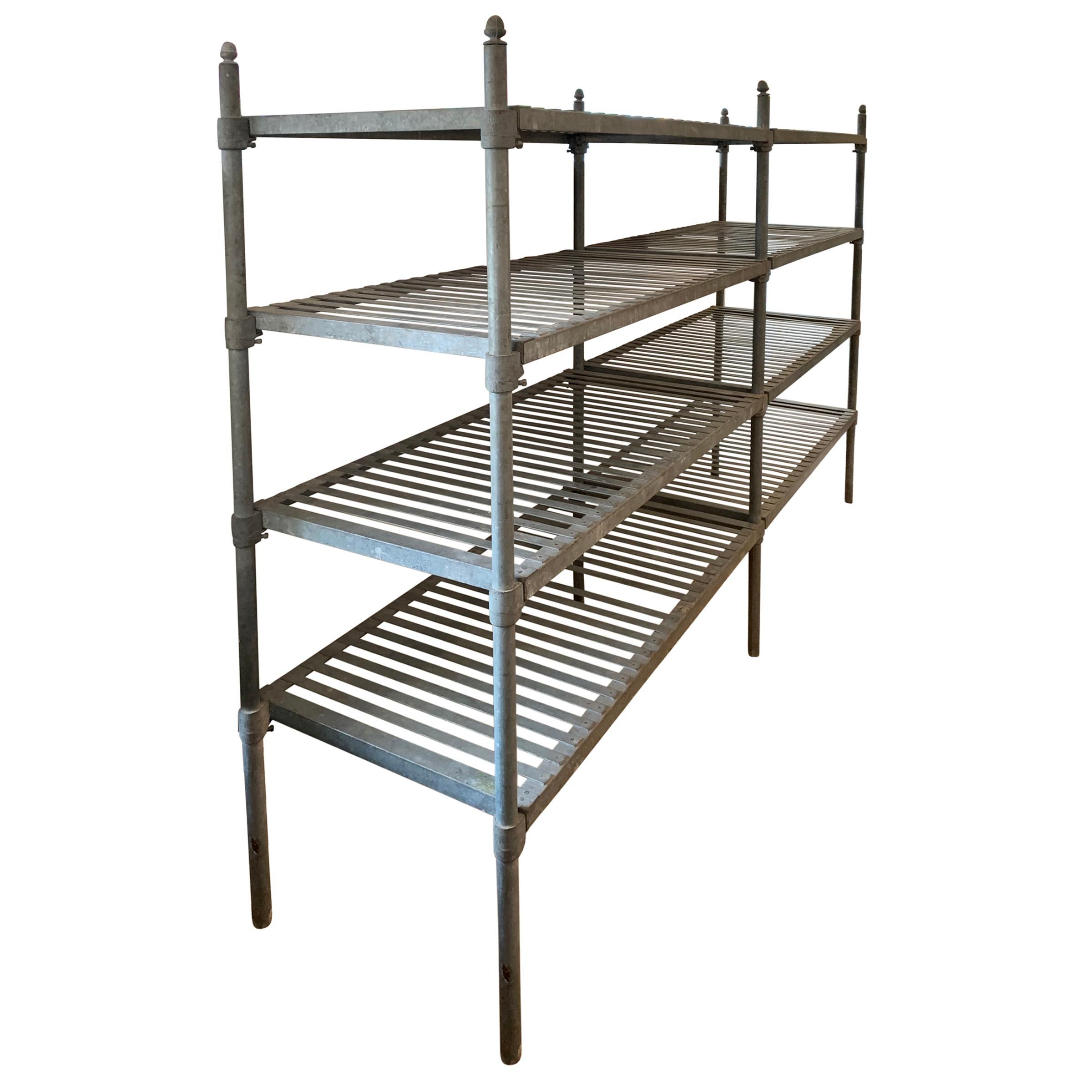 A fantastic early 20th century French industrial galvanized zinc shelving unit from a commercial kitchen or bakery with slatted shelves that can adjust in height, and whimsical acorn finials. The unit comes apart completely, and can even be