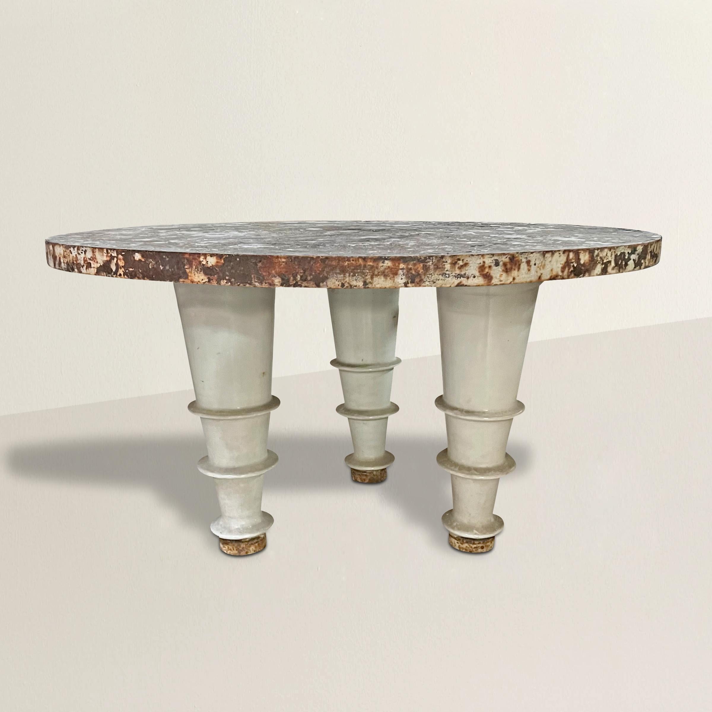 A chic and stylish early 20th century French industrial table with an iron wrapped cement top supported by three porcelain enameled iron legs.  Such a great center table in your loft apartment, but also works beautifully in your garden or on your