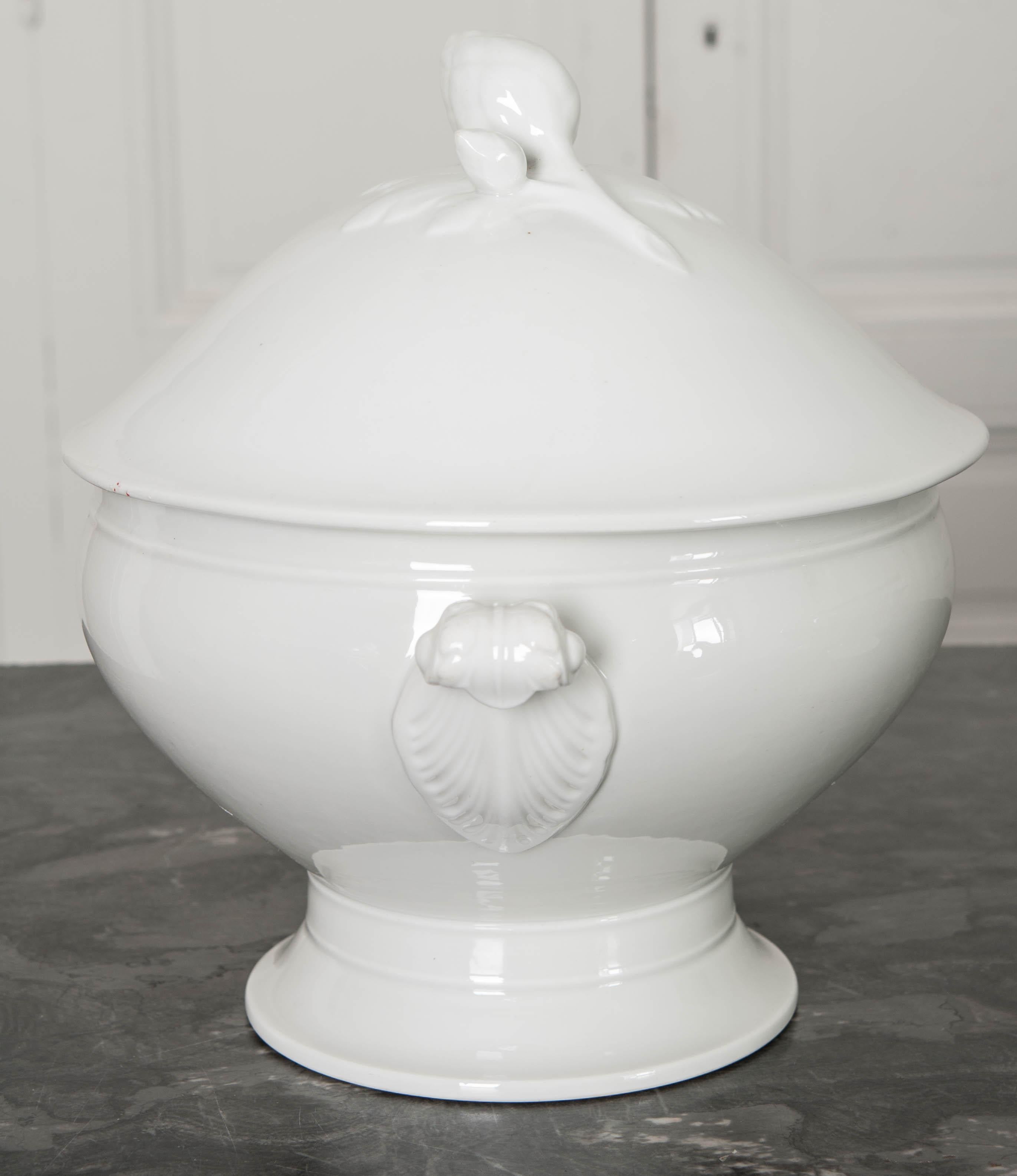 A gorgeous early 20th century white ironstone tureen, with fitted lid, from France. The stylish lid features a handle that is made in the form of a budding flower. The brilliant white finish is clean and unblemished, perfect for serving soups,