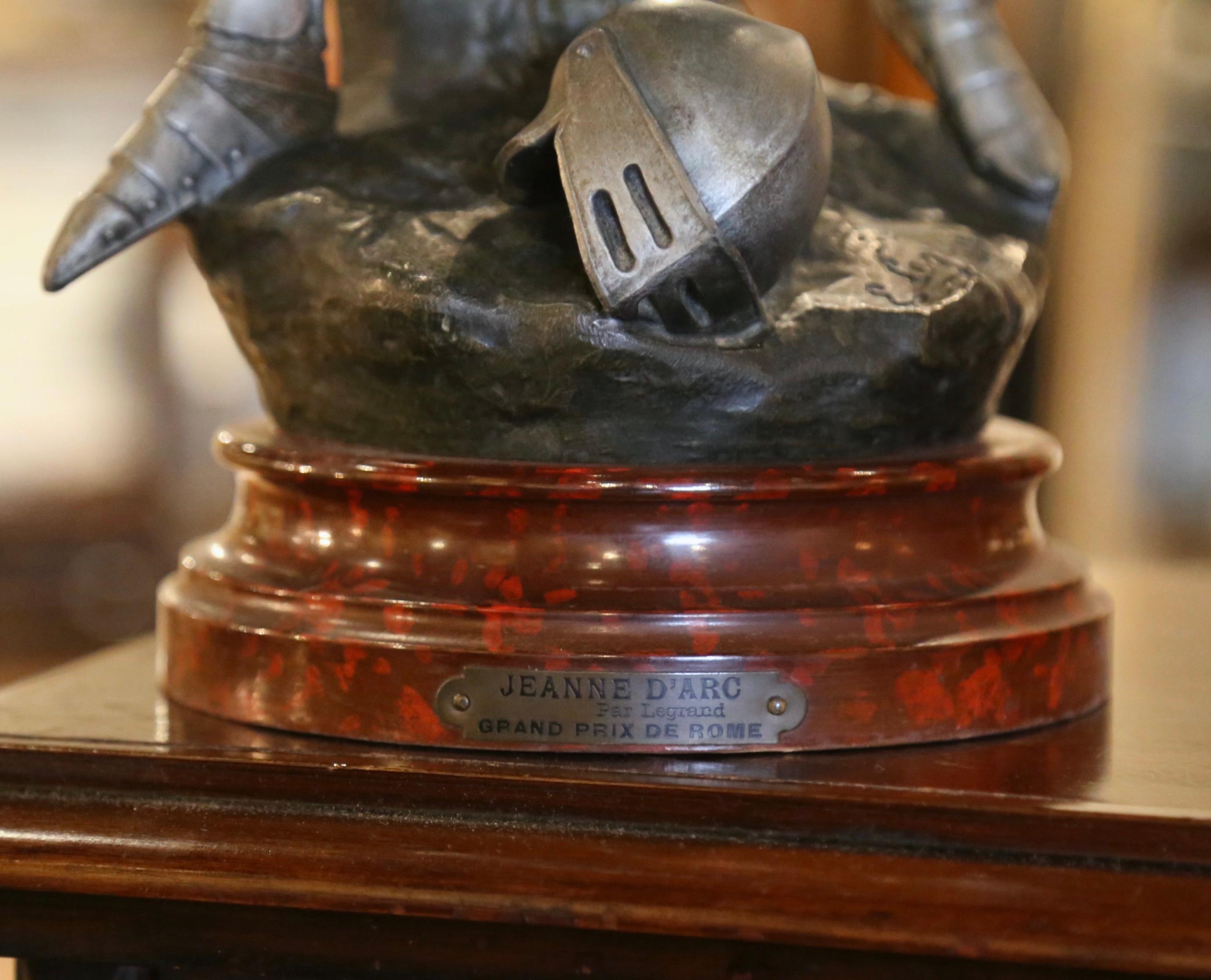 Realizzata in Francia intorno al 1900, l'antica scultura raffigura Sainte Jeanne d'Arc in piedi, vestita con un'armatura, che sventola poeticamente la bandiera della vittoria dopo la battaglia di Orleans. La scultura, firmata sulla base E. Legrand,