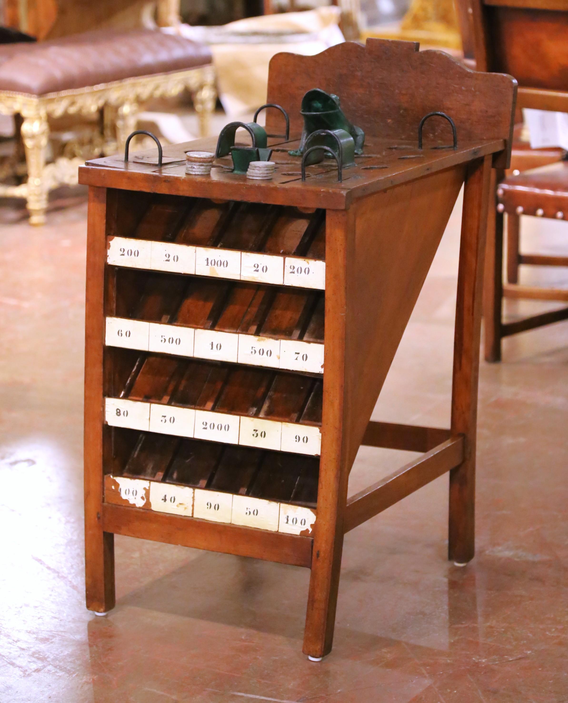 Porta in casa tua il fascino, il divertimento e l'autentica tradizione dei bistrot francesi con questo delizioso gioco del lancio delle monete La Grenouille dei primi del Novecento, realizzato in Francia intorno al 1920. Realizzato in caldo legno di