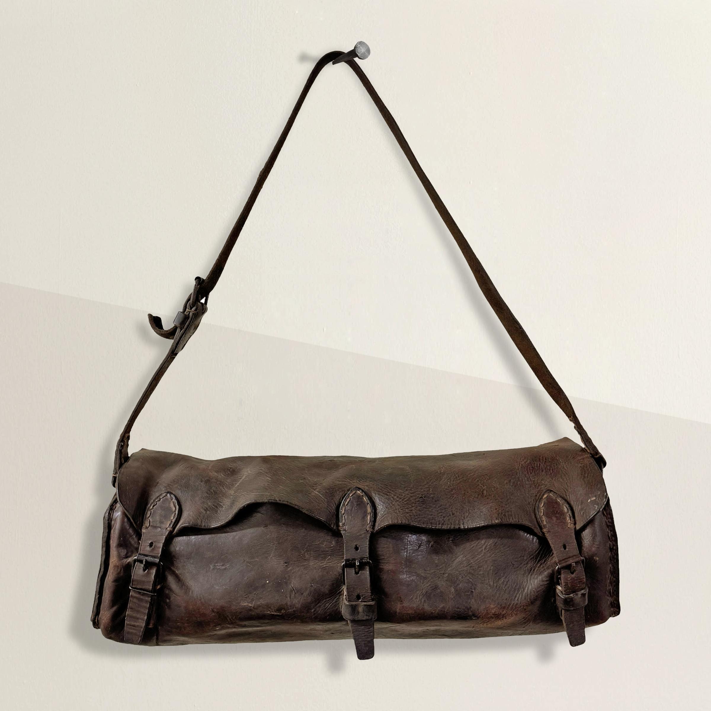 Questa borsa per attrezzi in pelle francese dell'inizio del XX secolo proviene dalla Société Nationale des Chemins de fer Français (SNCF), il servizio ferroviario nazionale francese istituito nel 1938. Originariamente progettata per contenere gli