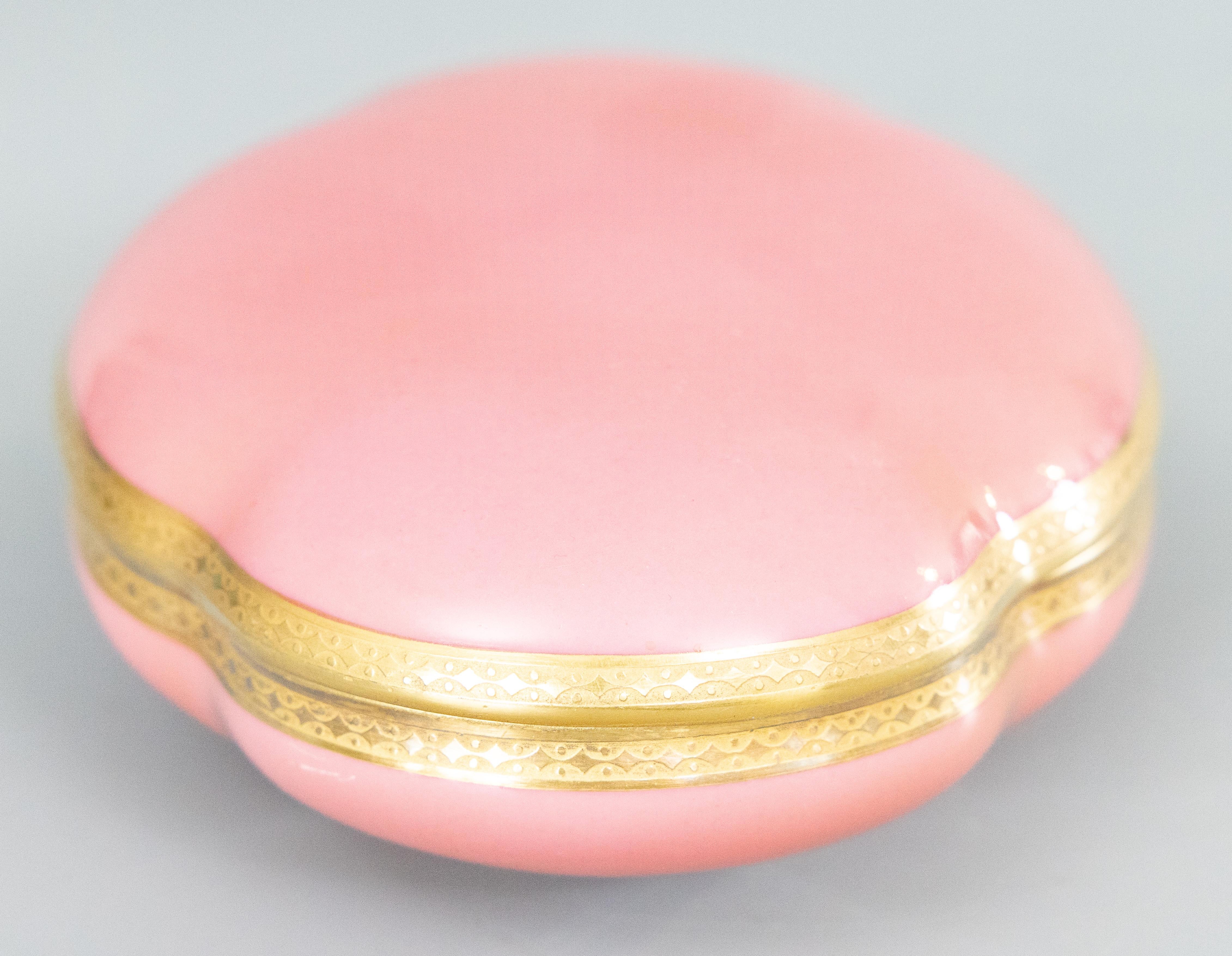 A stunning antique French pink porcelain lidded jewelry box by Theodore Haviland, Limoges, France, circa 1900-1920. Maker's mark on reverse. This gorgeous box has a stylish serpentine design in a lovely shade of pink with gilt accents. It displays